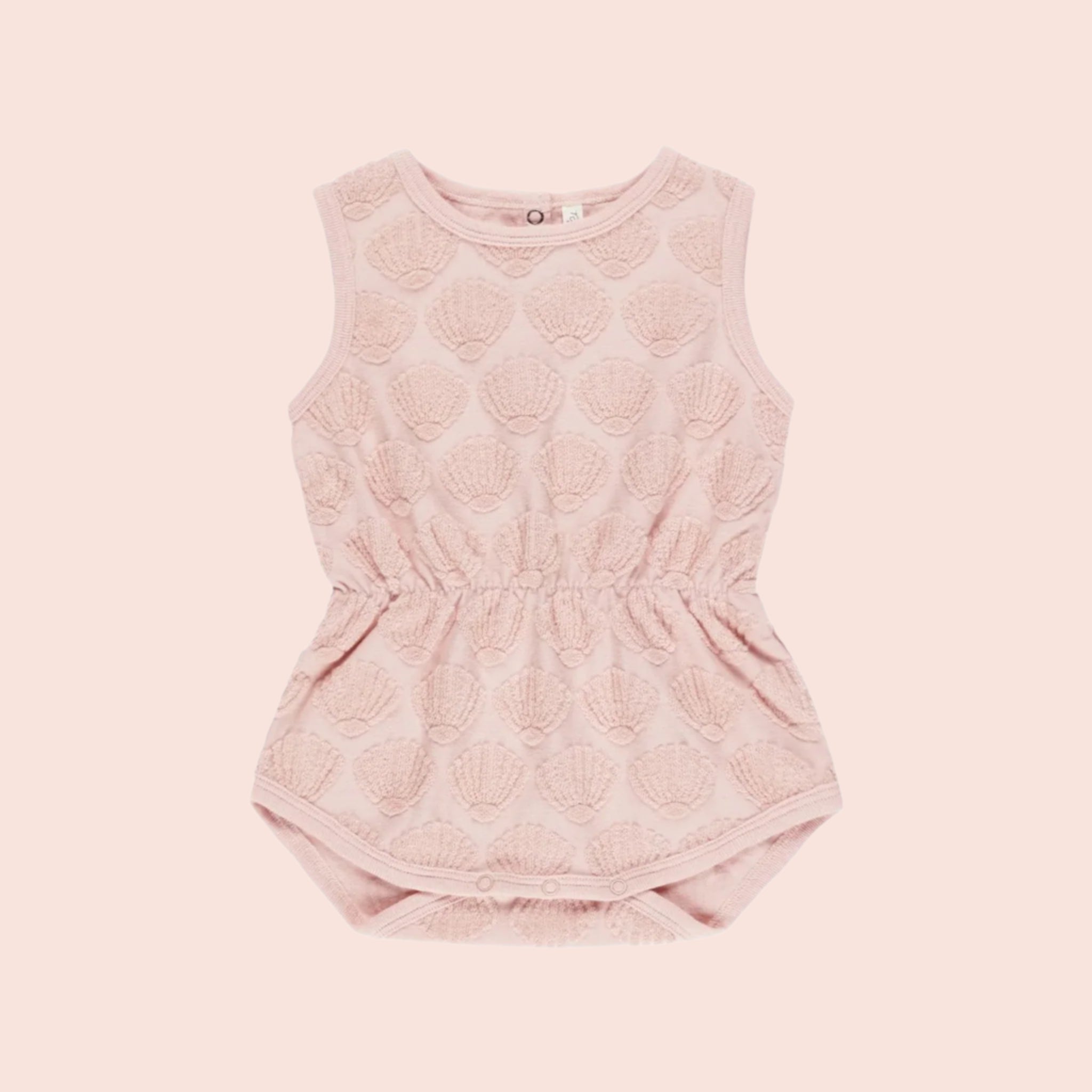 A pink kids sleeveless jumpsuit with a pink seashell pattern. 