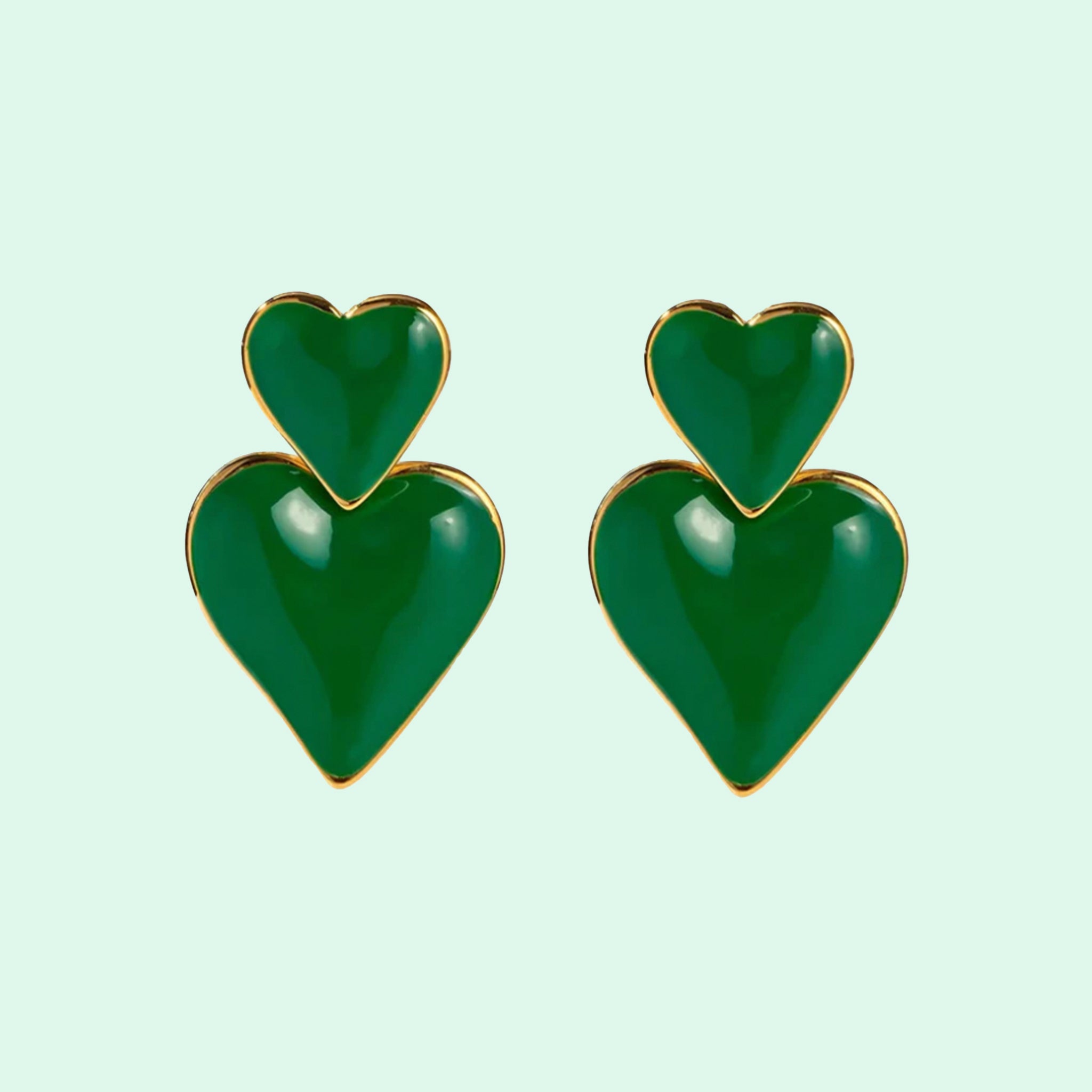 A pair of green earrings in the shape of a double heart stacked on top of one another. 