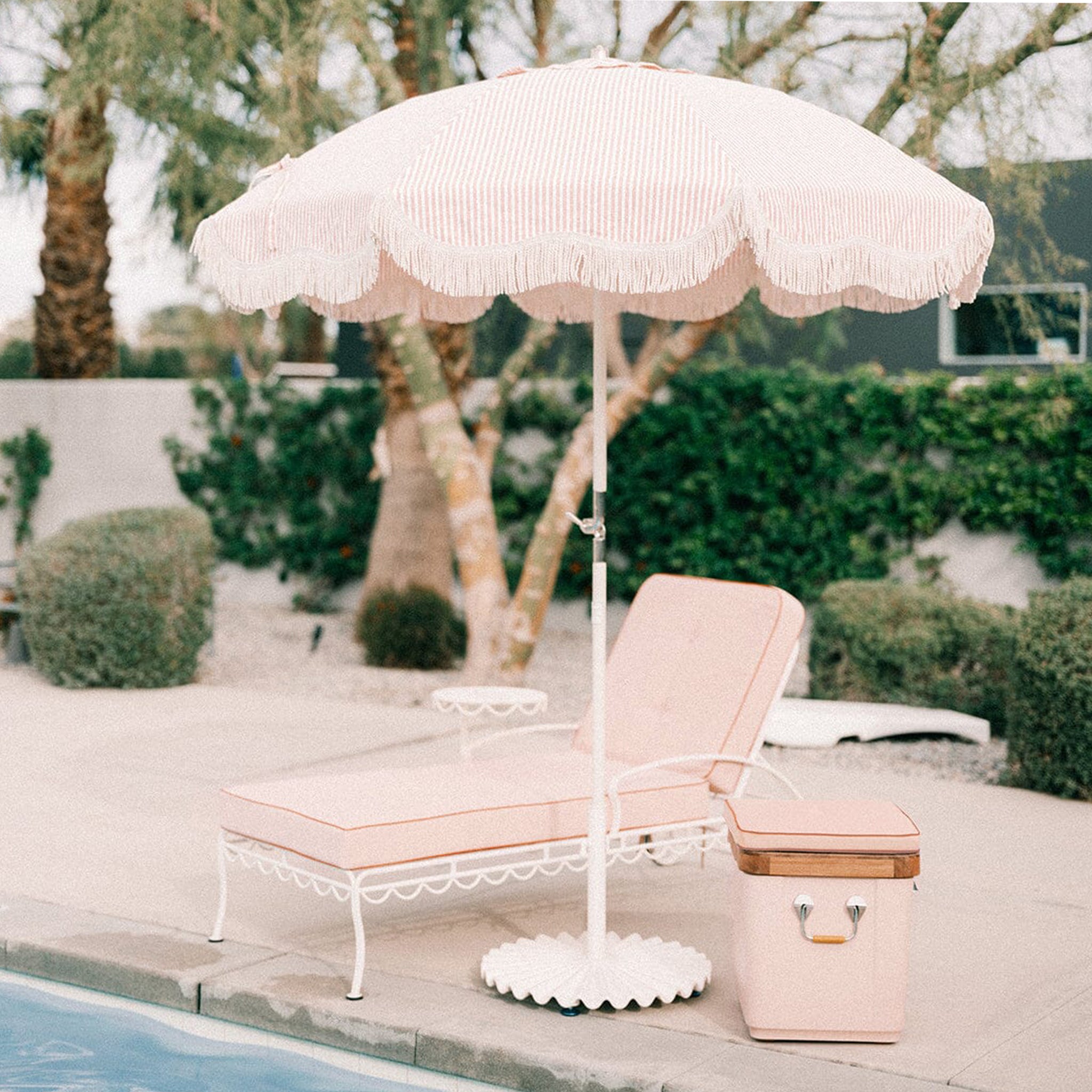 A wavy umbrella base in an antique white color holding an umbrella sold separately. 