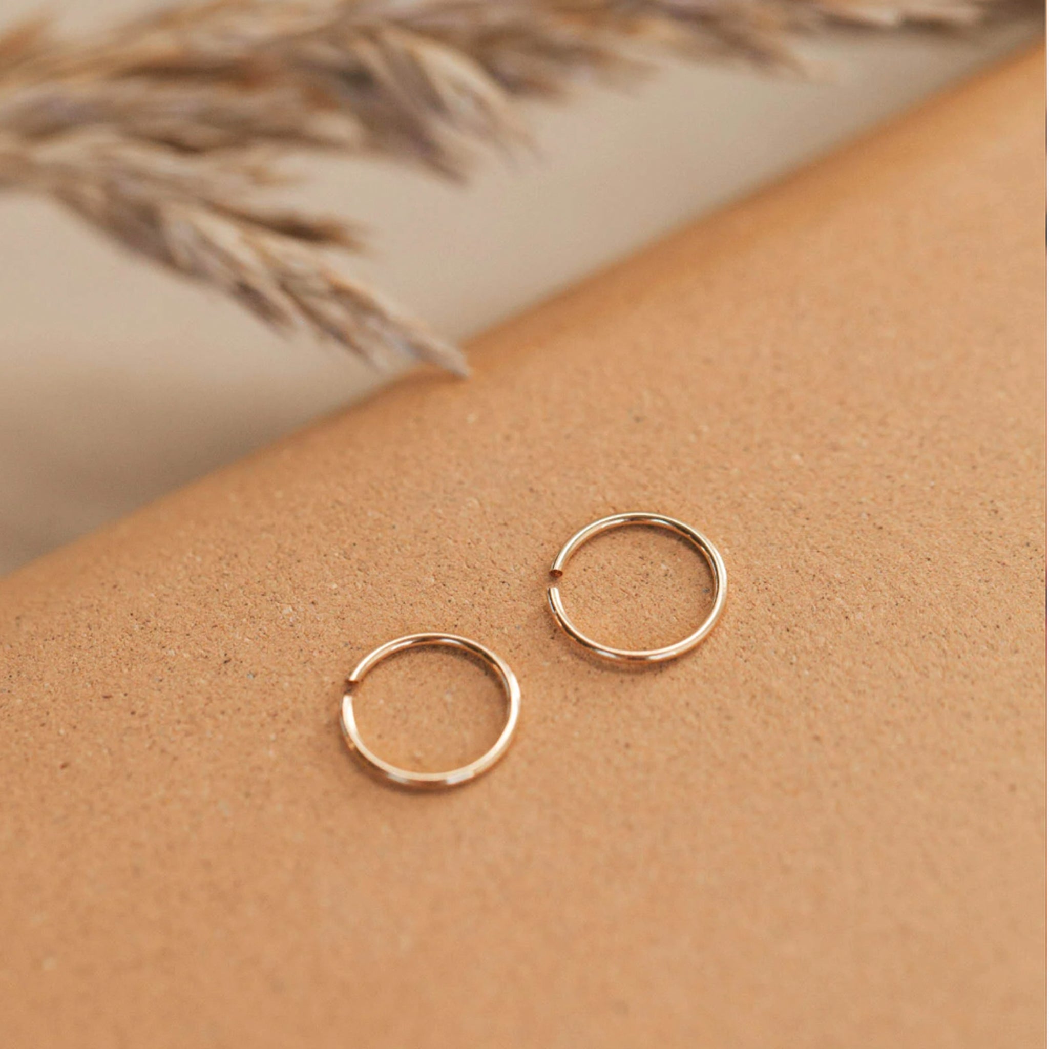 A pair of tiny gold hoops in three different sizes. Each pair sold separately. 