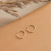 A pair of tiny gold hoops in three different sizes. Each pair sold separately. 