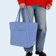 A blue nylon tote bag with two handle straps and a front pocket.