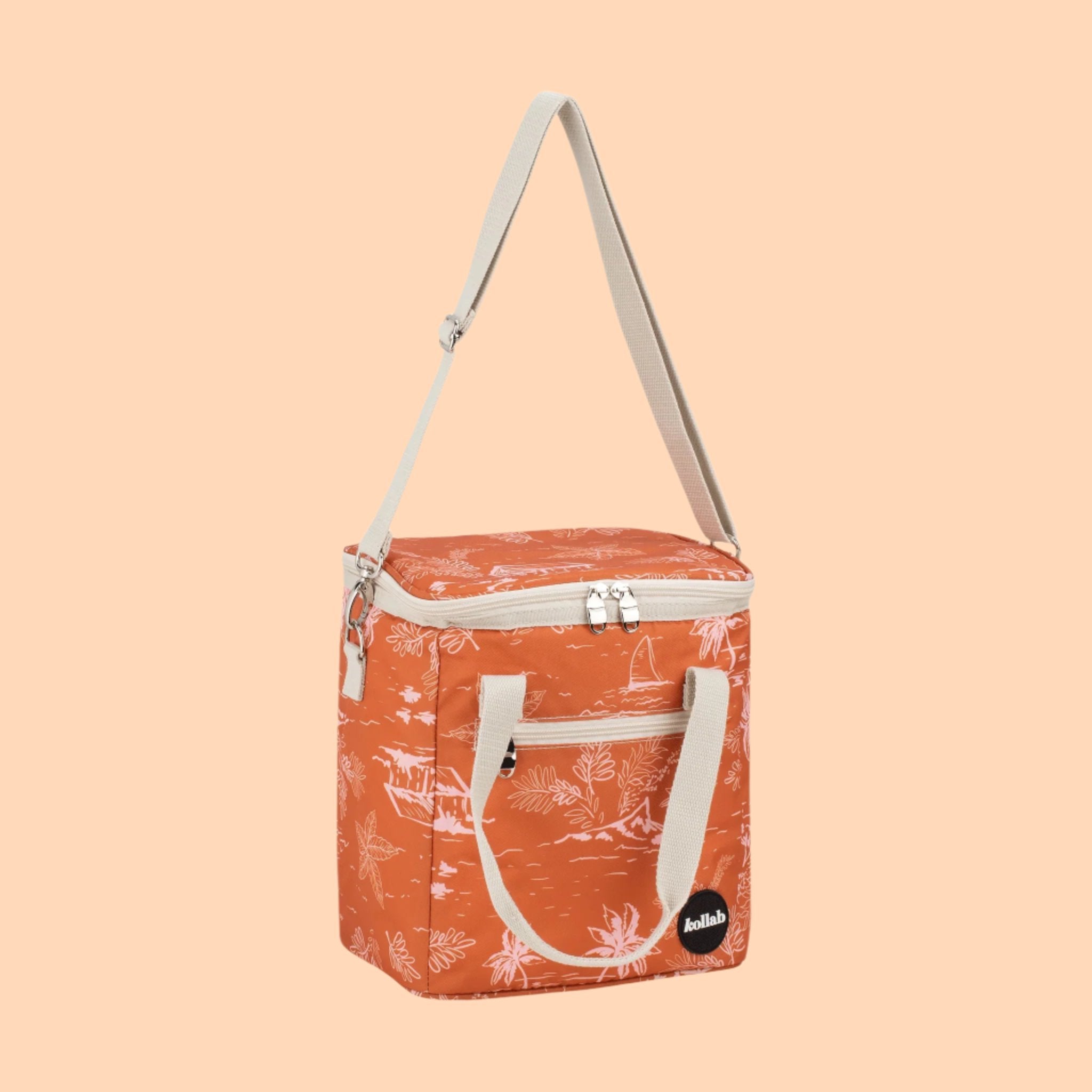 An orange mini cooler bag with a coastal pattern and ivory canvas straps and handles. 