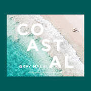 On a blue background is a Gray Malin book cover with one of his ocean photography shots as well as white text that reads, "COASTAL".