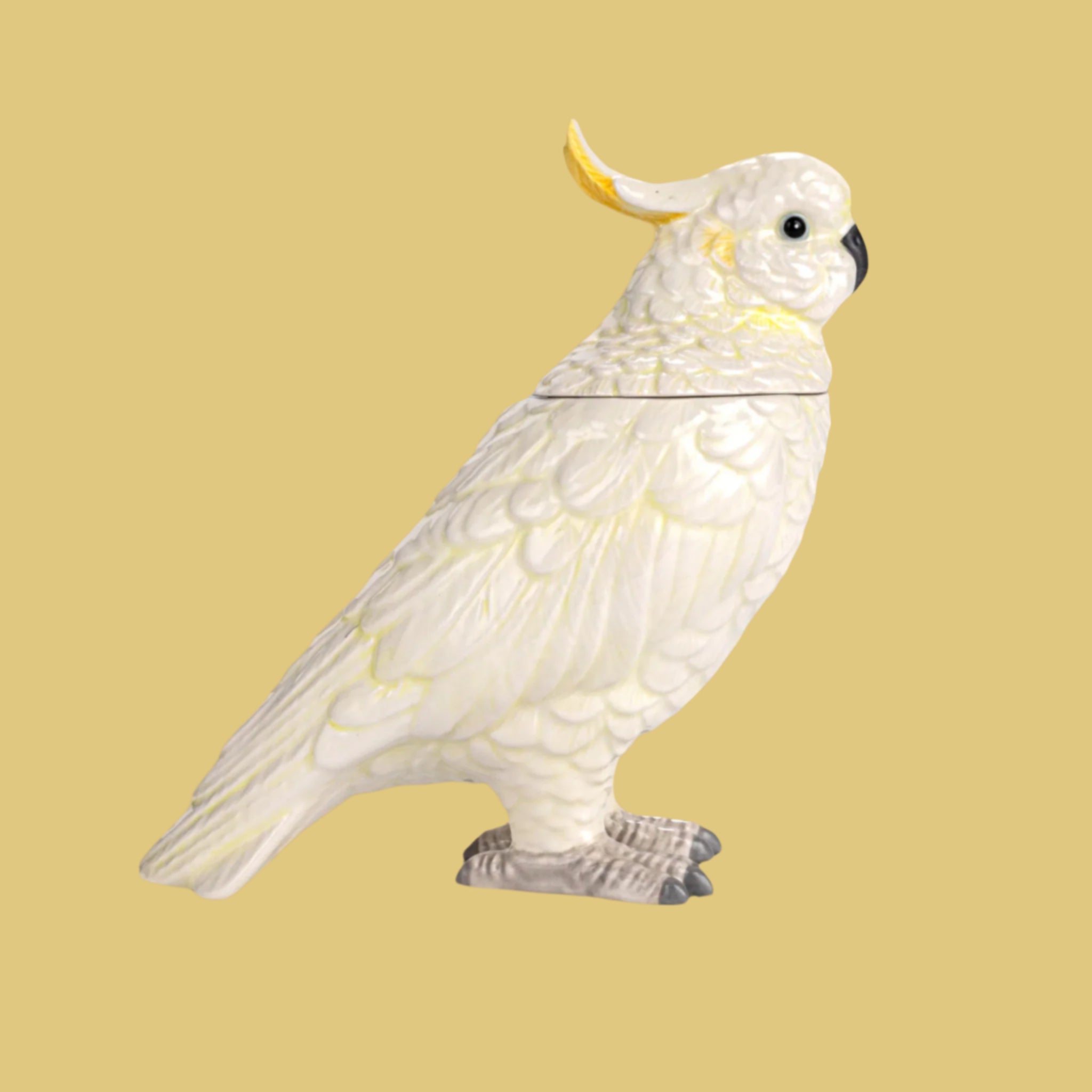 A white and yellow cockatoo shaped jar with a removable lid. 