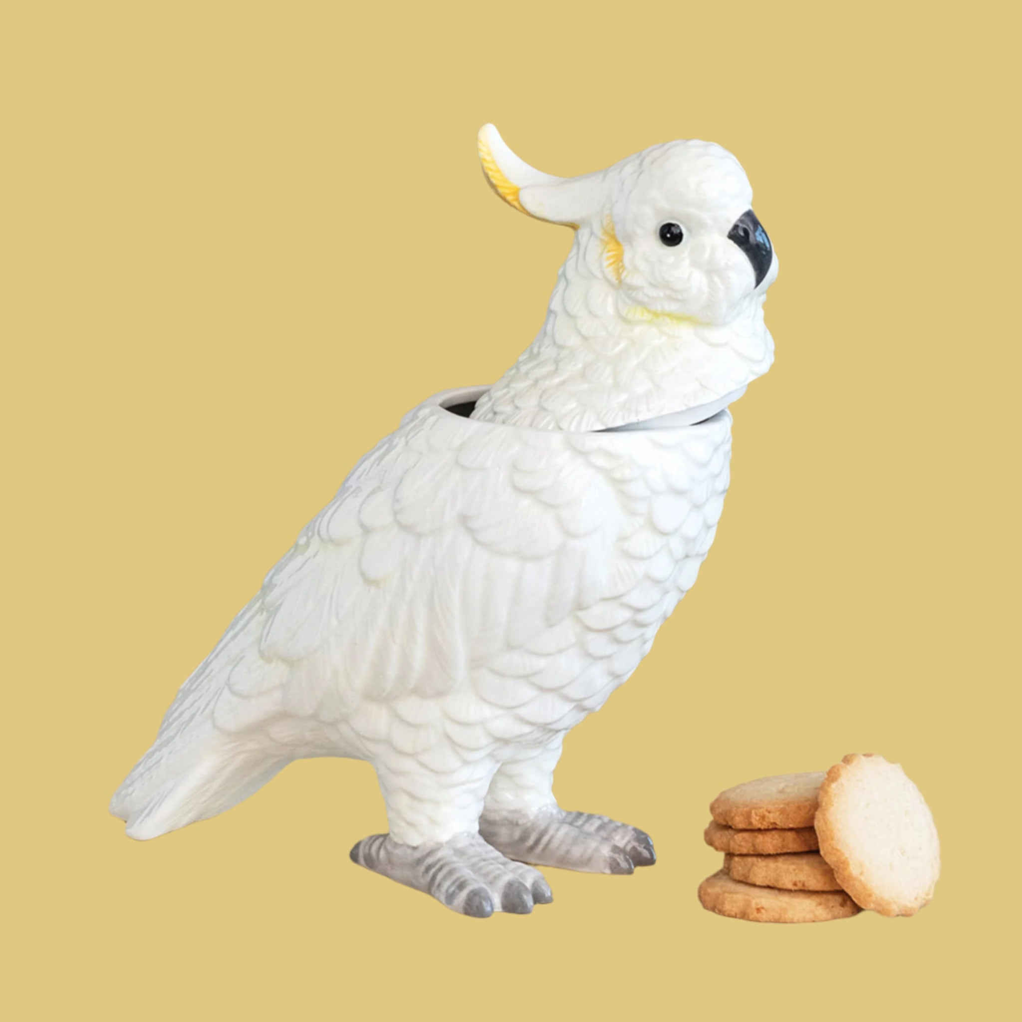 A white and yellow cockatoo shaped jar with a removable lid. 