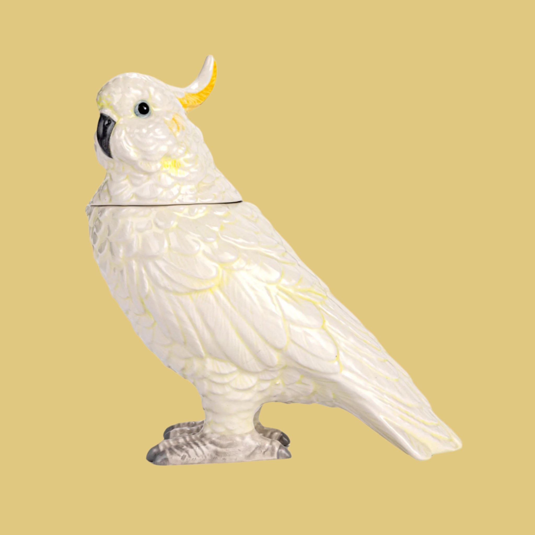 A white and yellow cockatoo shaped jar with a removable lid. 