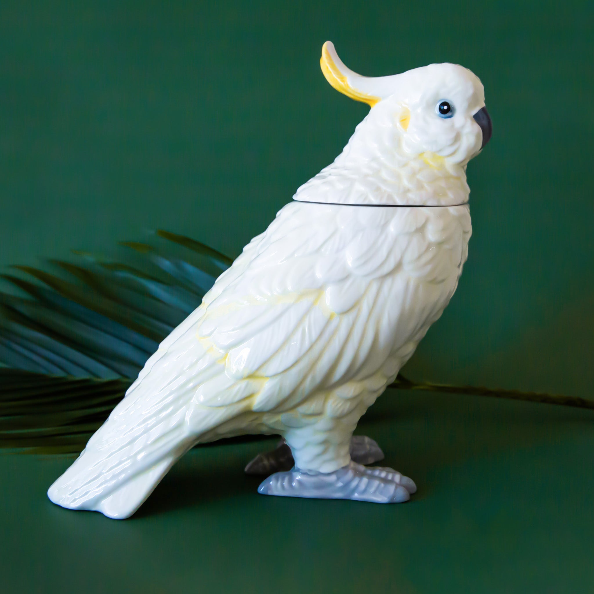 A white and yellow cockatoo shaped jar with a removable lid. 