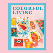 A blue and pink book cover with colorful design and lifestyle items with text above that reads, 'Colorful Living'. 