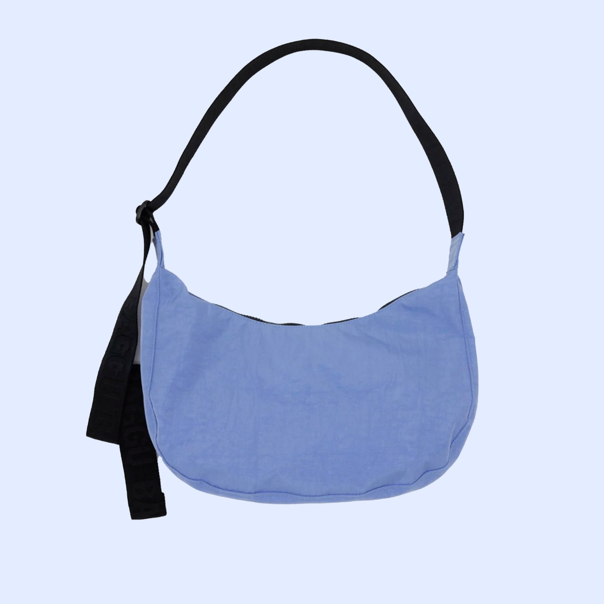 A blue nylon crescent shaped handbag with a black adjustable strap. 