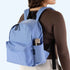 A blue nylon backpack with a side pocket and front zip pockets and black details. 