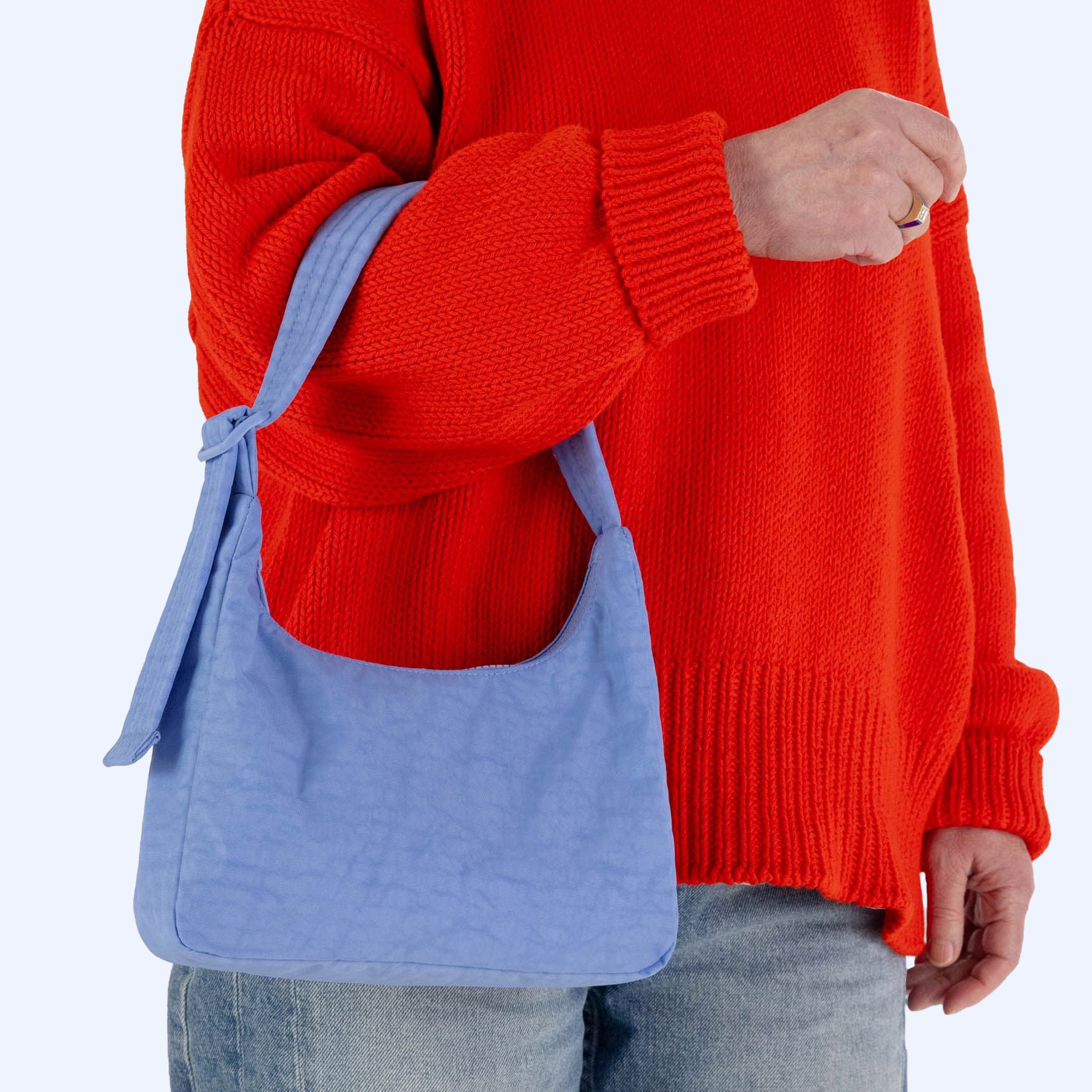 A blue squared off nylon shoulder bag with an adjustable strap. 