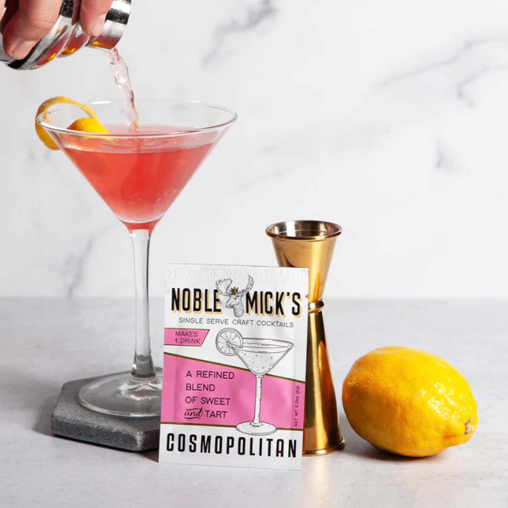 A pink and white packet of craft cocktail mix that says, &quot;Noble Mick&#39;s Single Serve Craft Cocktails&quot; along with a martini glass.