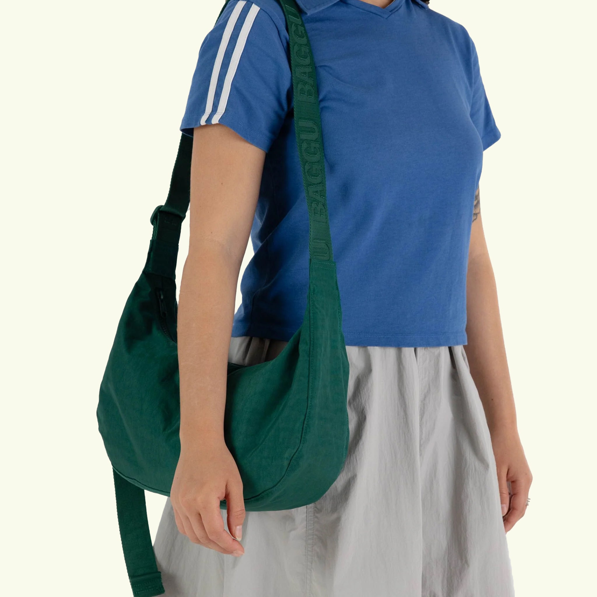 A dark green nylon handbag with a adjustable strap. 