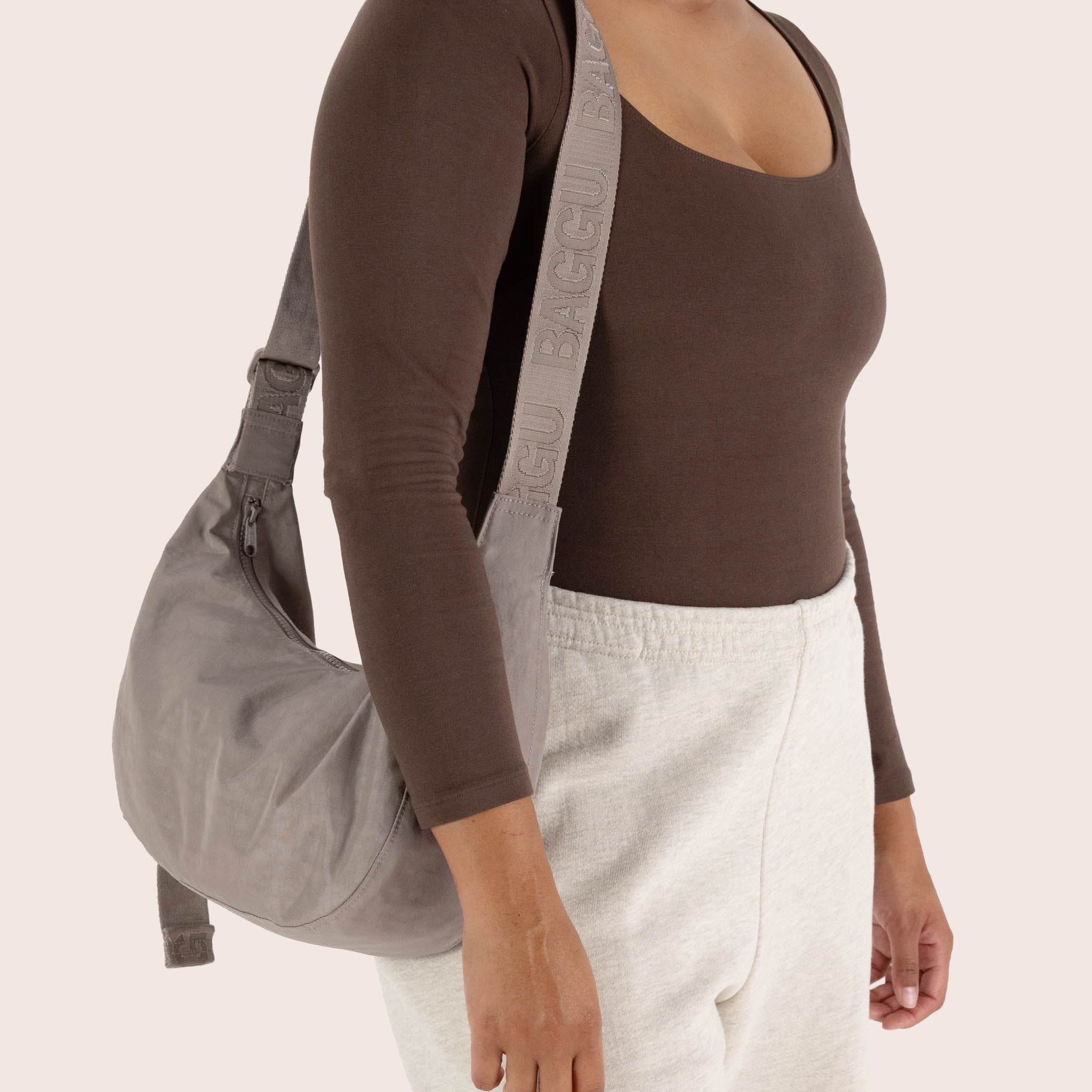 A crescent shaped nylon handbag with a shoulder strap.