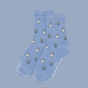 A blue pair of crew socks with a white Miffy and flower pattern. 