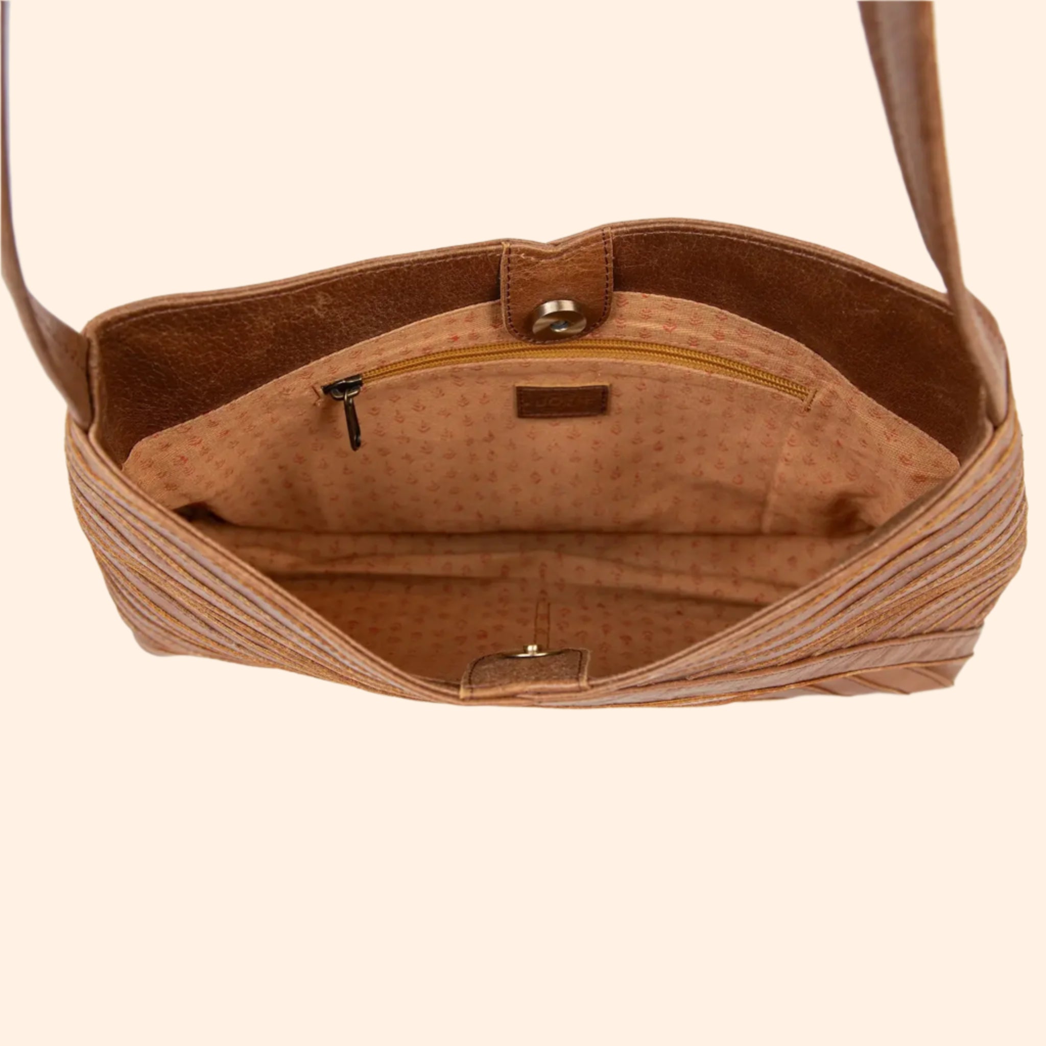 A vintage brown crisscross handbag with a shoulder strap and an interior zip pocket and button closure.