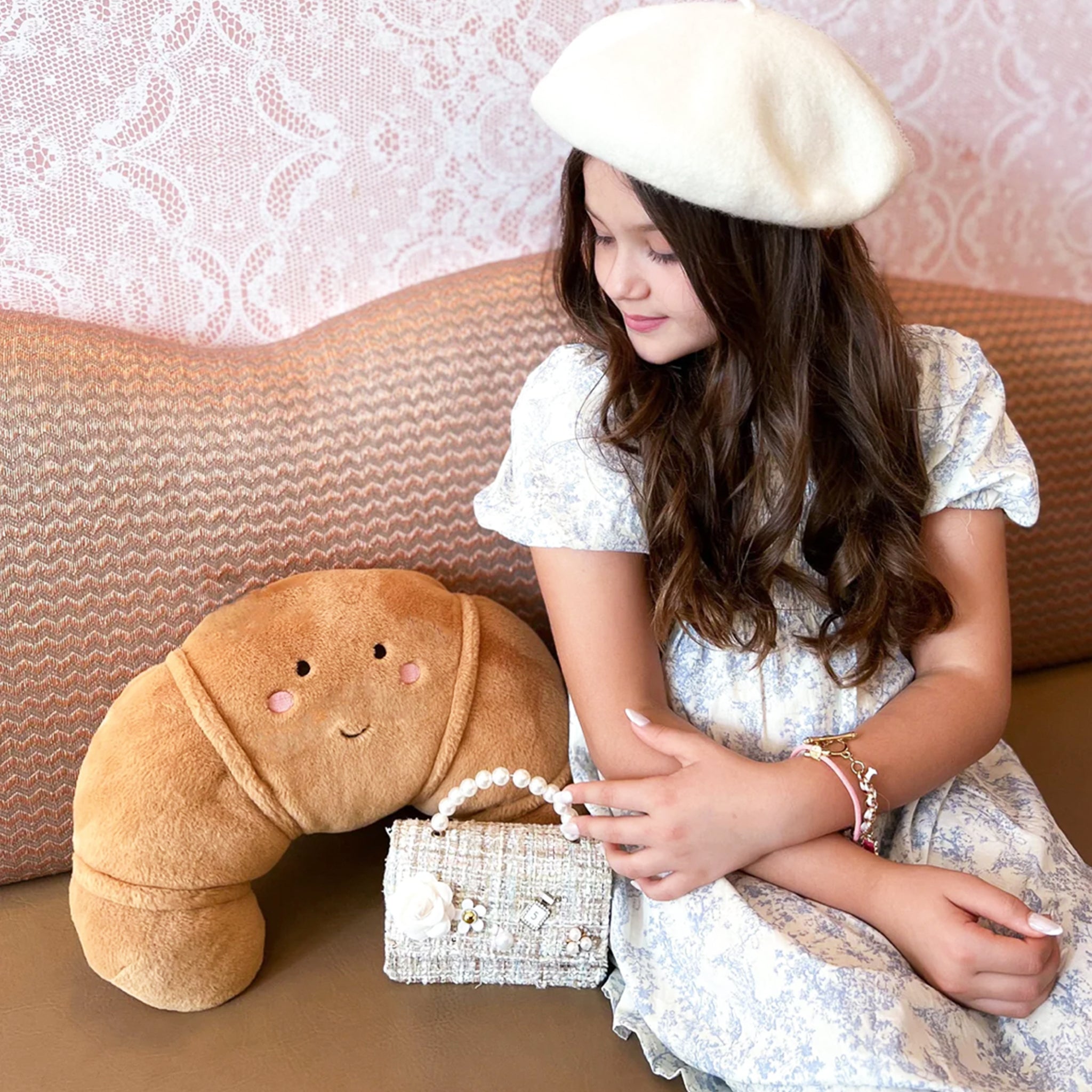 A large croissant shaped stuffed toy with a smiley face. 