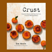 A white book cover with orange pastries on the front and text that reads, 'Crust'. 