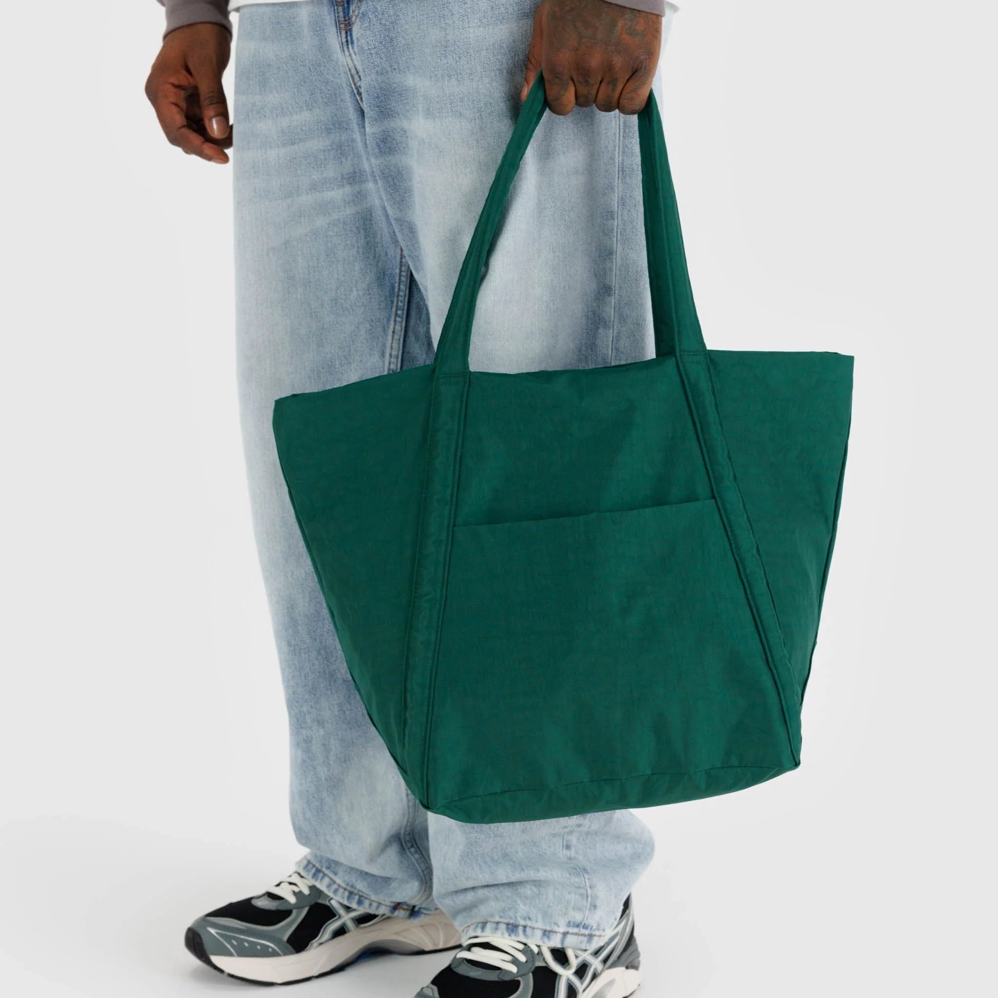 A dark green nylon tote bag with two hand straps and a front pocket. 