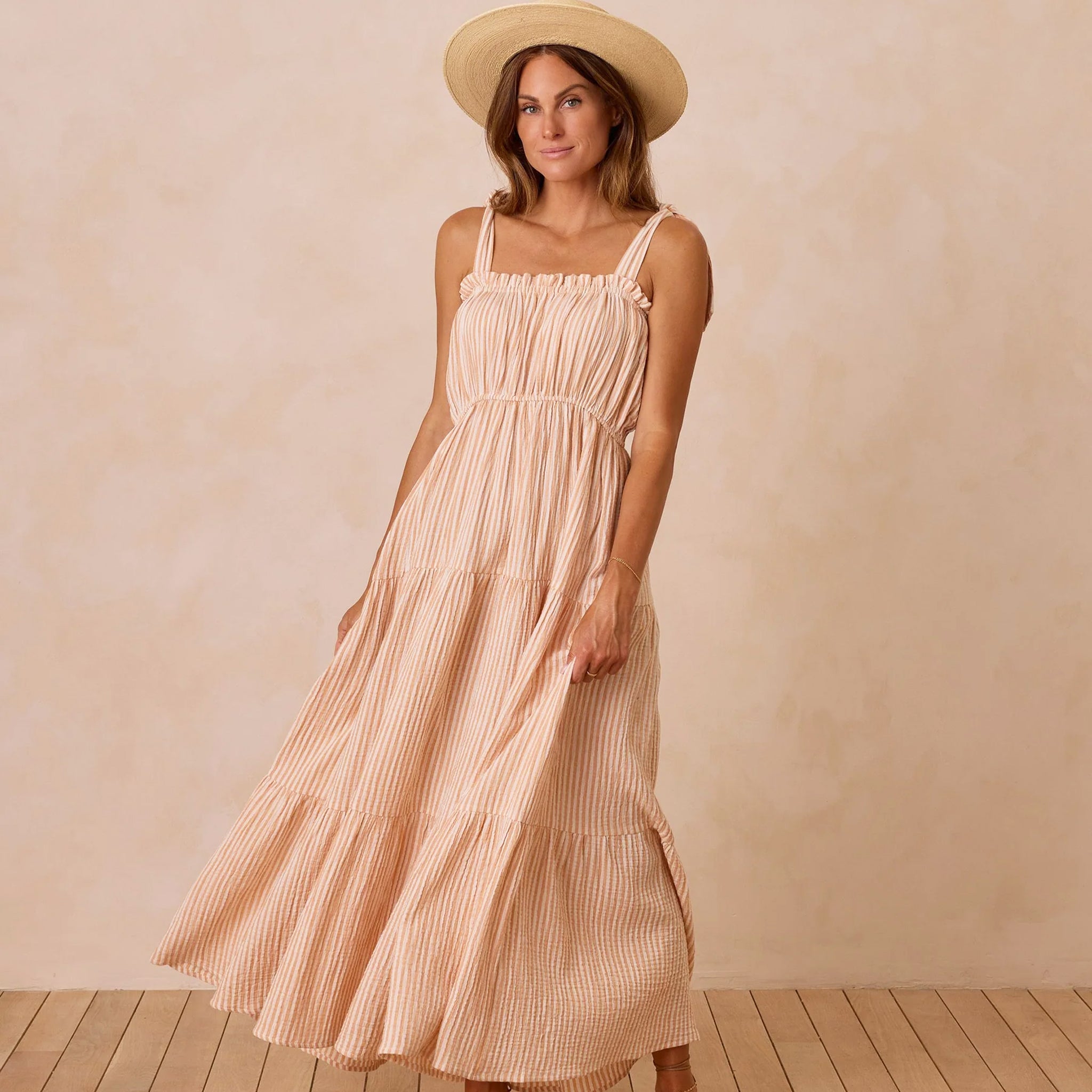 A light orange and ivory striped tired maxi dress with an elastic neckline. 