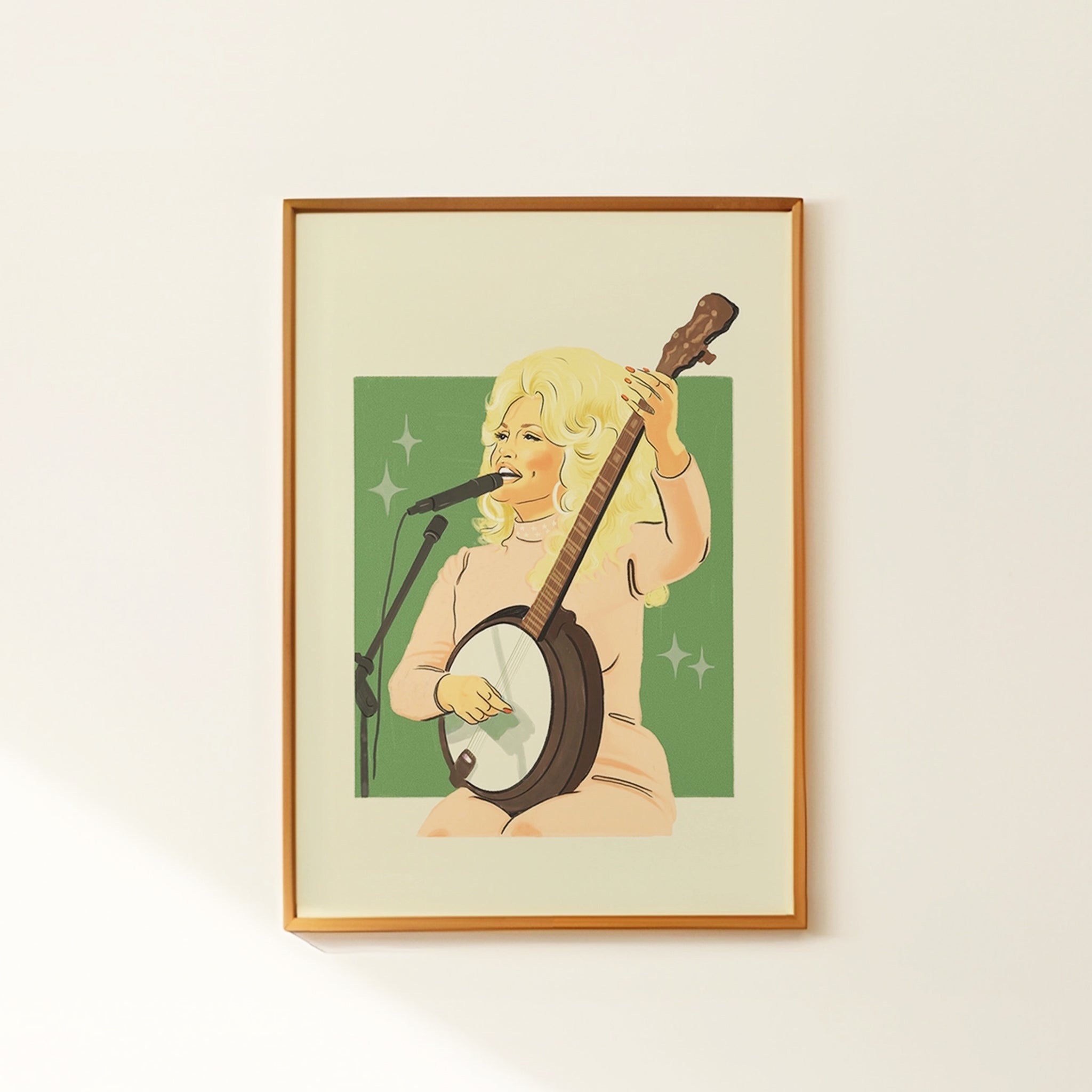 An art print of Dolly Parton signing and holding her banjo with a green background and her in pink. Frame not included. 