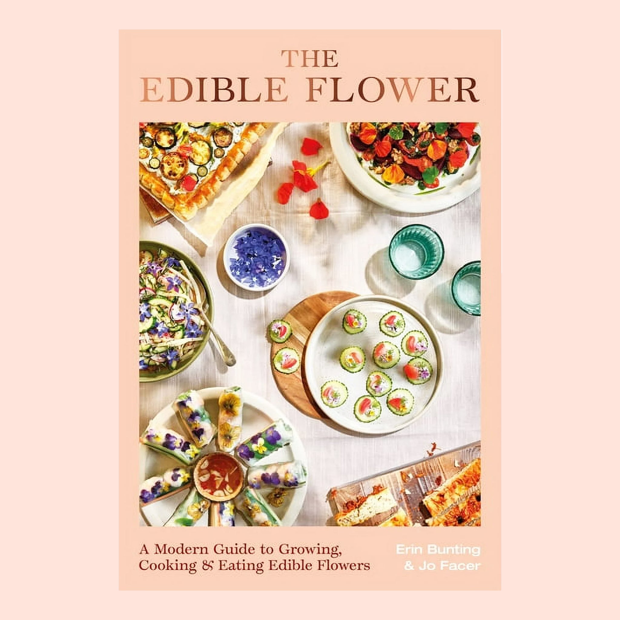 A light peachy colored book cover with colorful foods plated with edible flowers and the title at the top that reads, "The Edible Flower". 