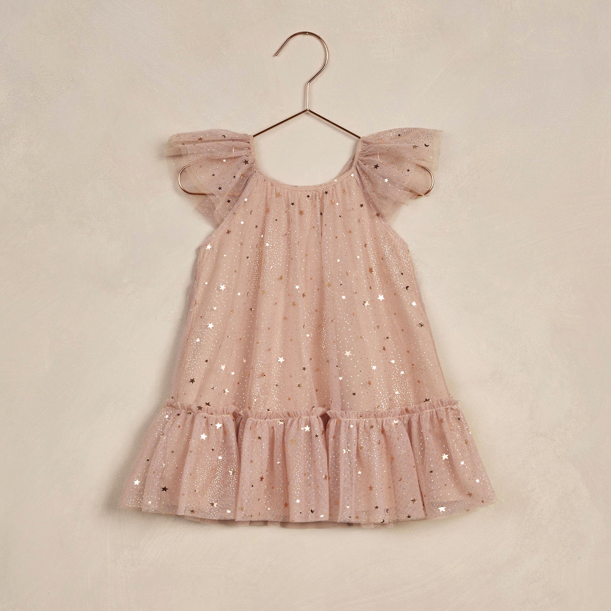 A pink tulle dress with flutter sleeves, and rose gold stars. 