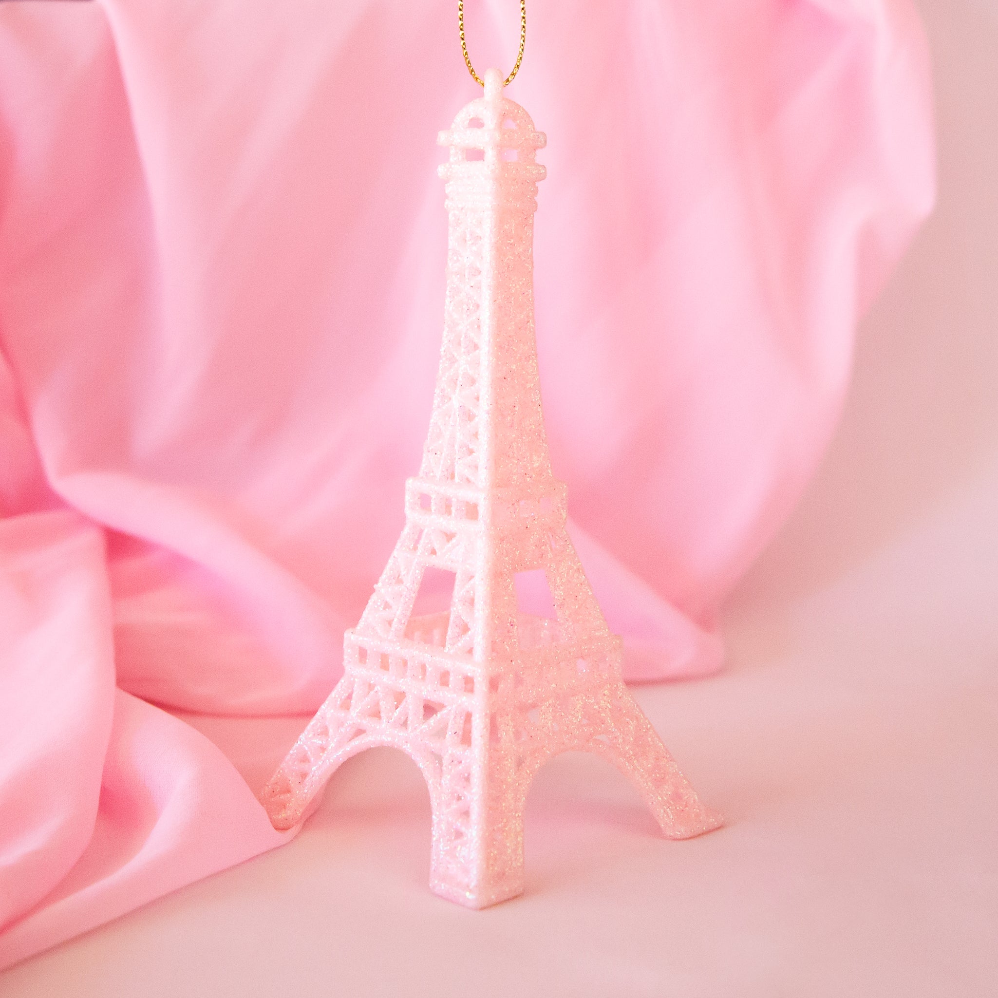 A plastic light pink Eiffel Tower shaped ornament. 