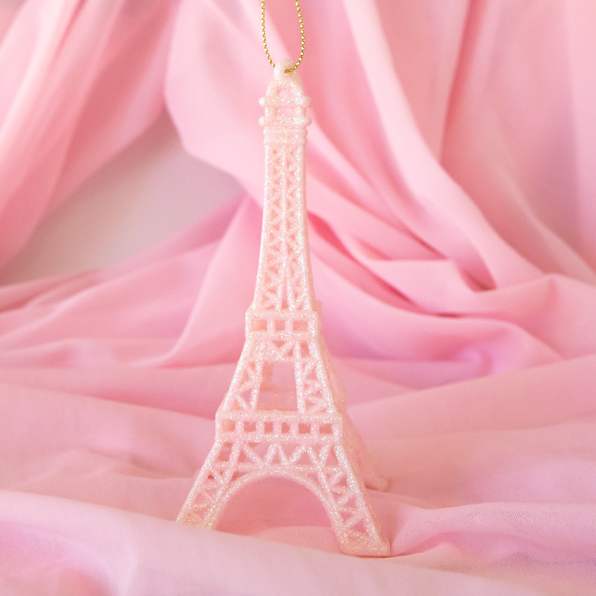 A plastic light pink Eiffel Tower shaped ornament. 