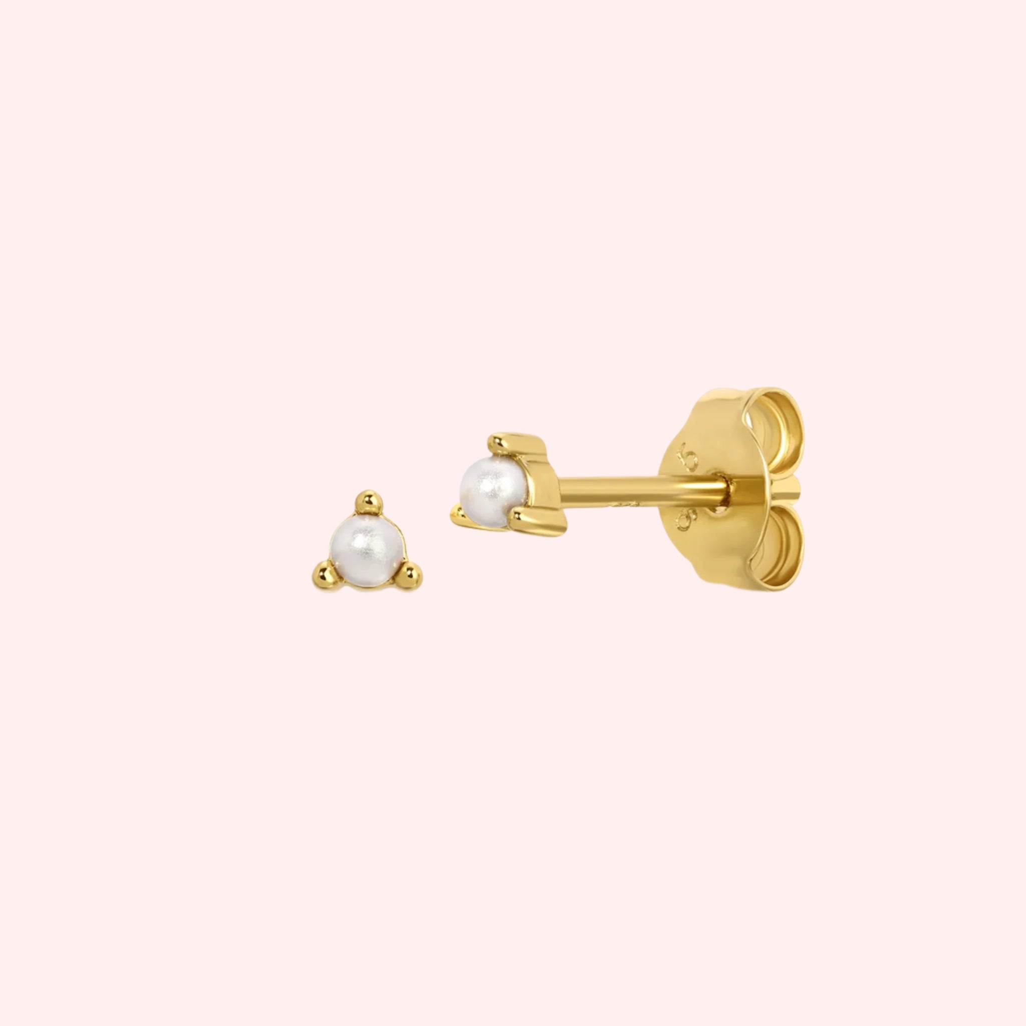 A gold stud earring with a pearl stud in the center. 