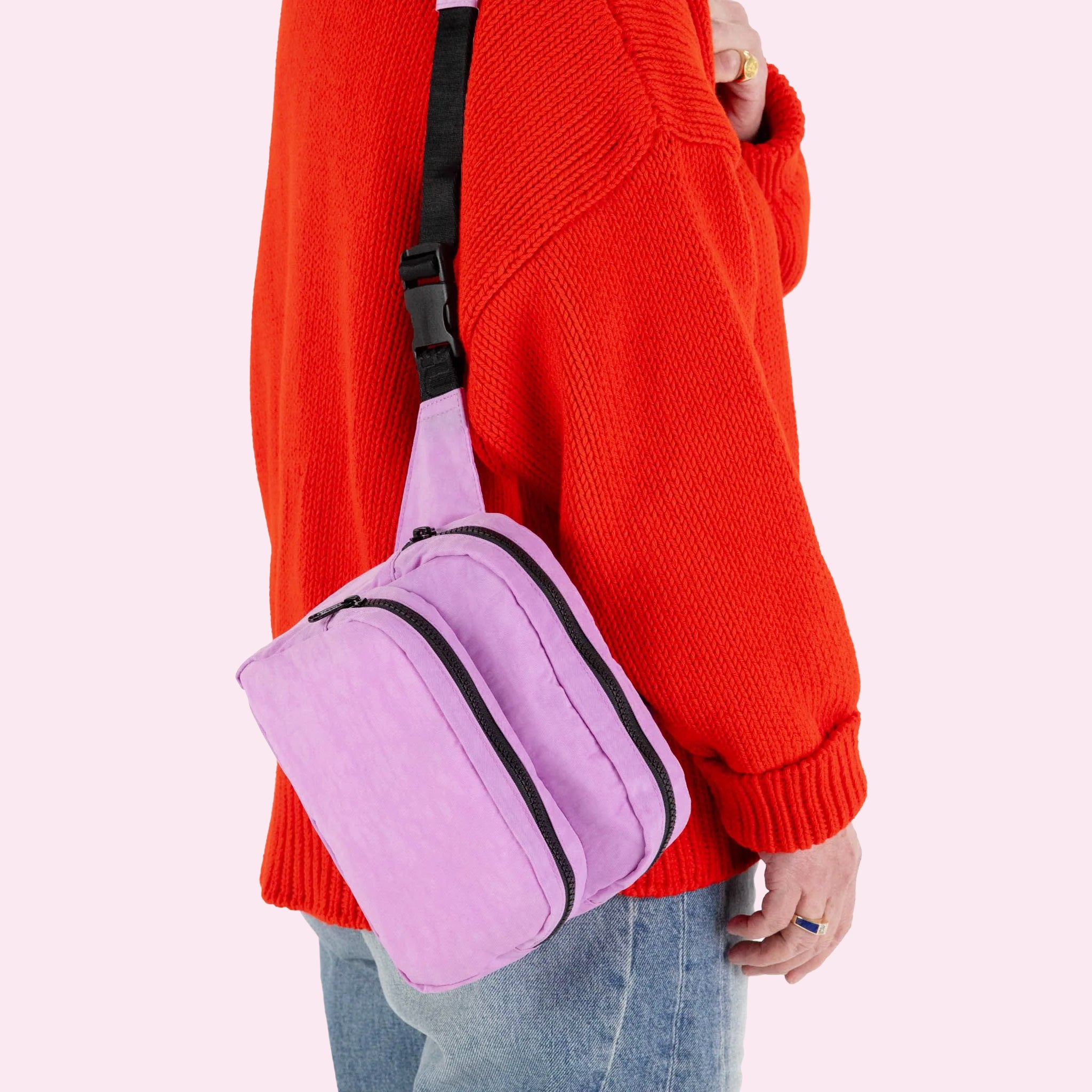 A bright pink and black fanny pack with an adjustable strap. 