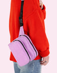 A bright pink and black fanny pack with an adjustable strap. 