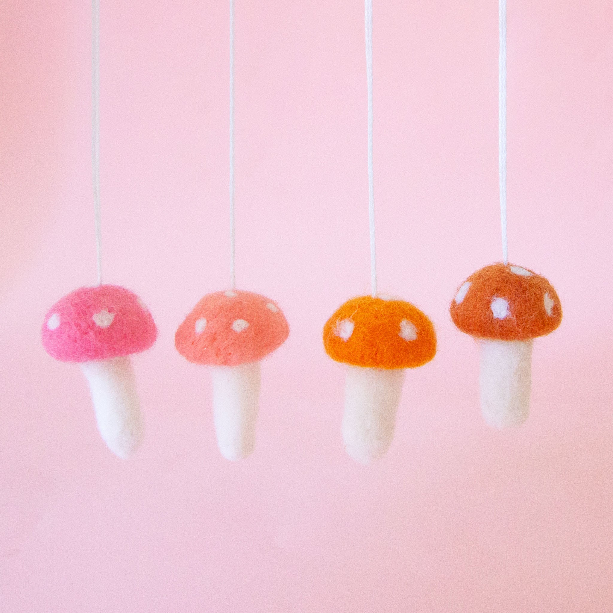 Four felt mushroom ornaments in different colors. 