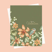 A green card with a peachy floral pattern and a bird illustration along with text that reads, 'To My Valentine'. 