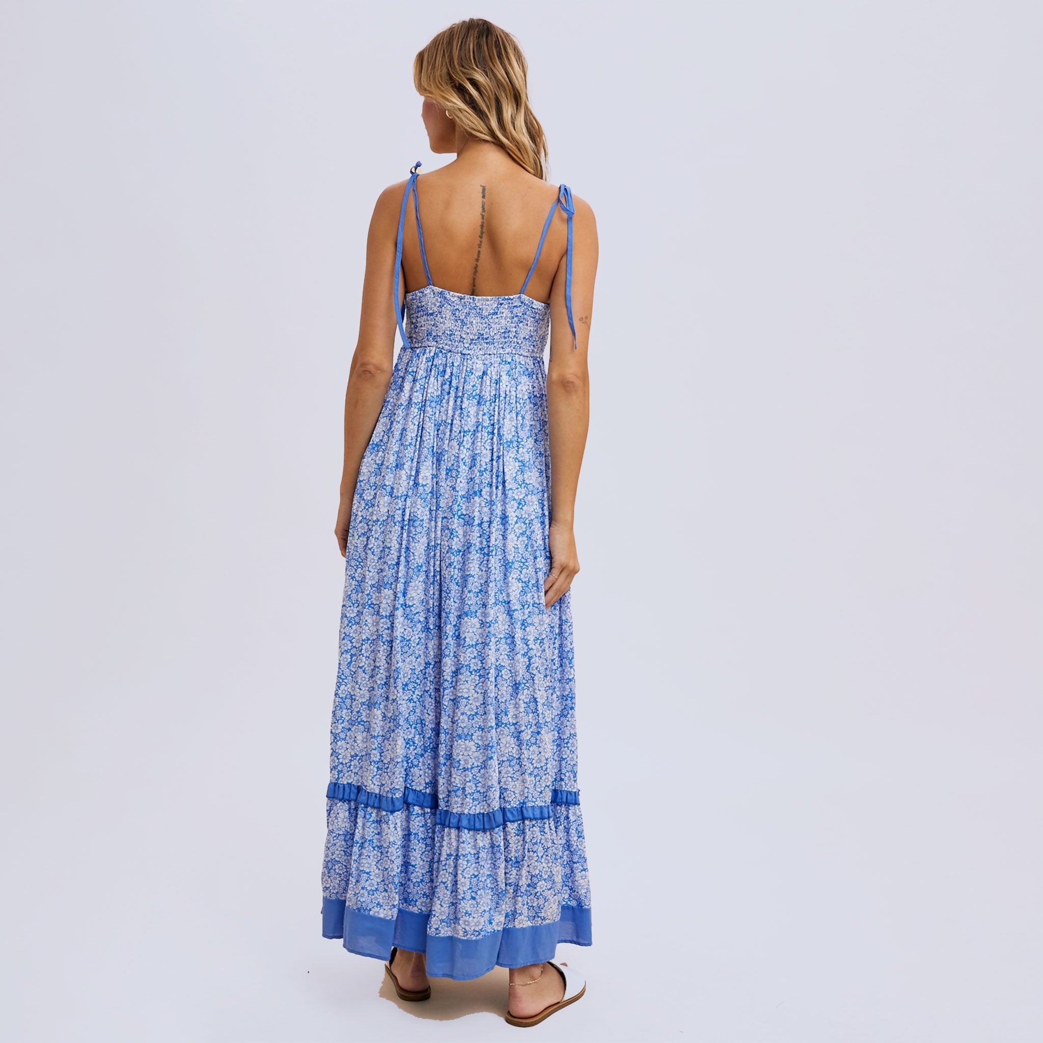 a blue flowy floral maxi dress with tie shoulder strap details. 