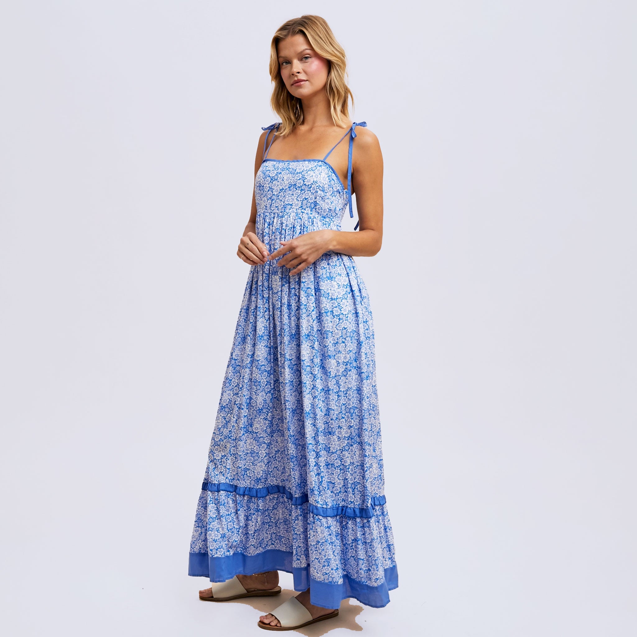 a blue flowy floral maxi dress with tie shoulder strap details. 