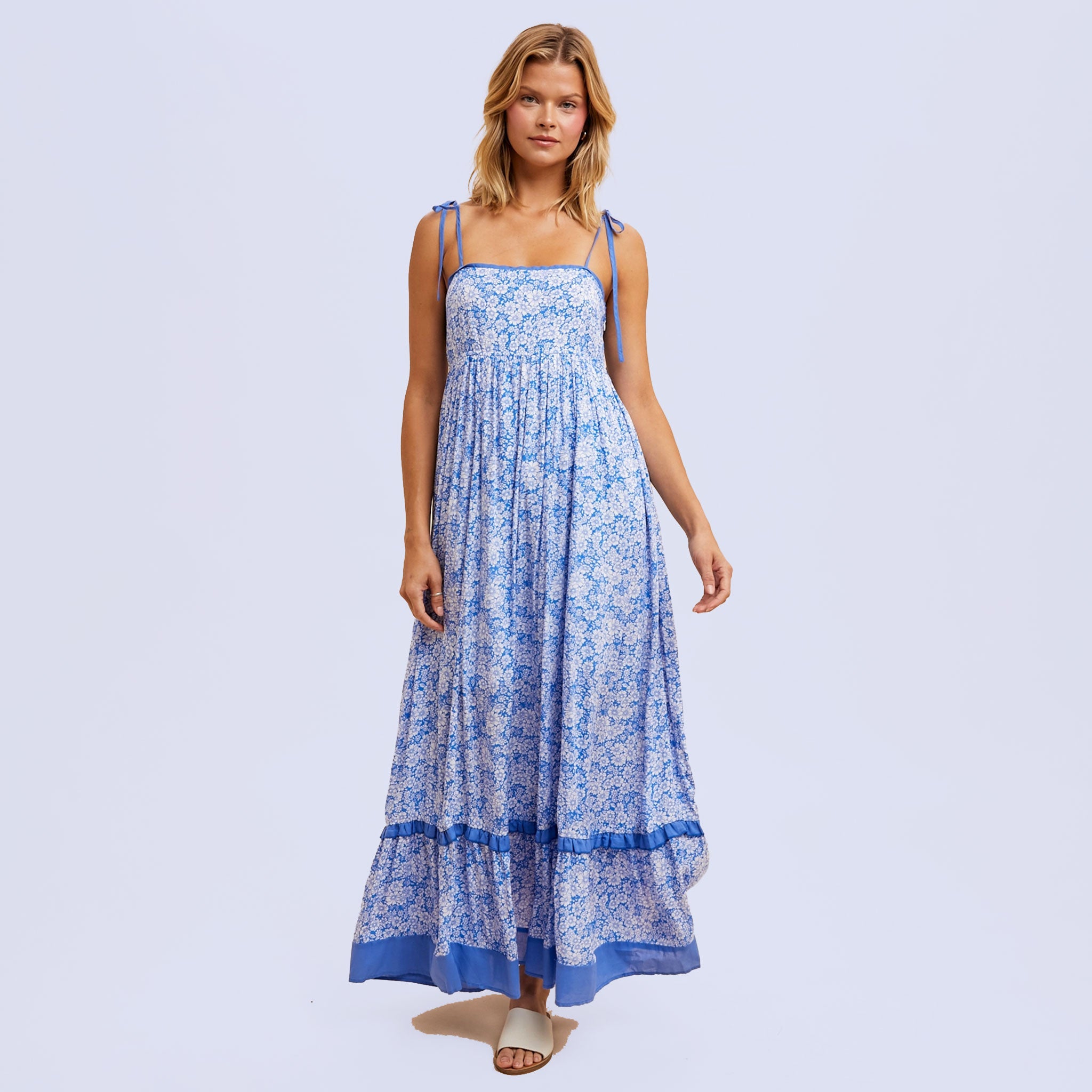 a blue flowy floral maxi dress with tie shoulder strap details. 