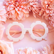 White flower shaped sunglasses with light pink lenses.