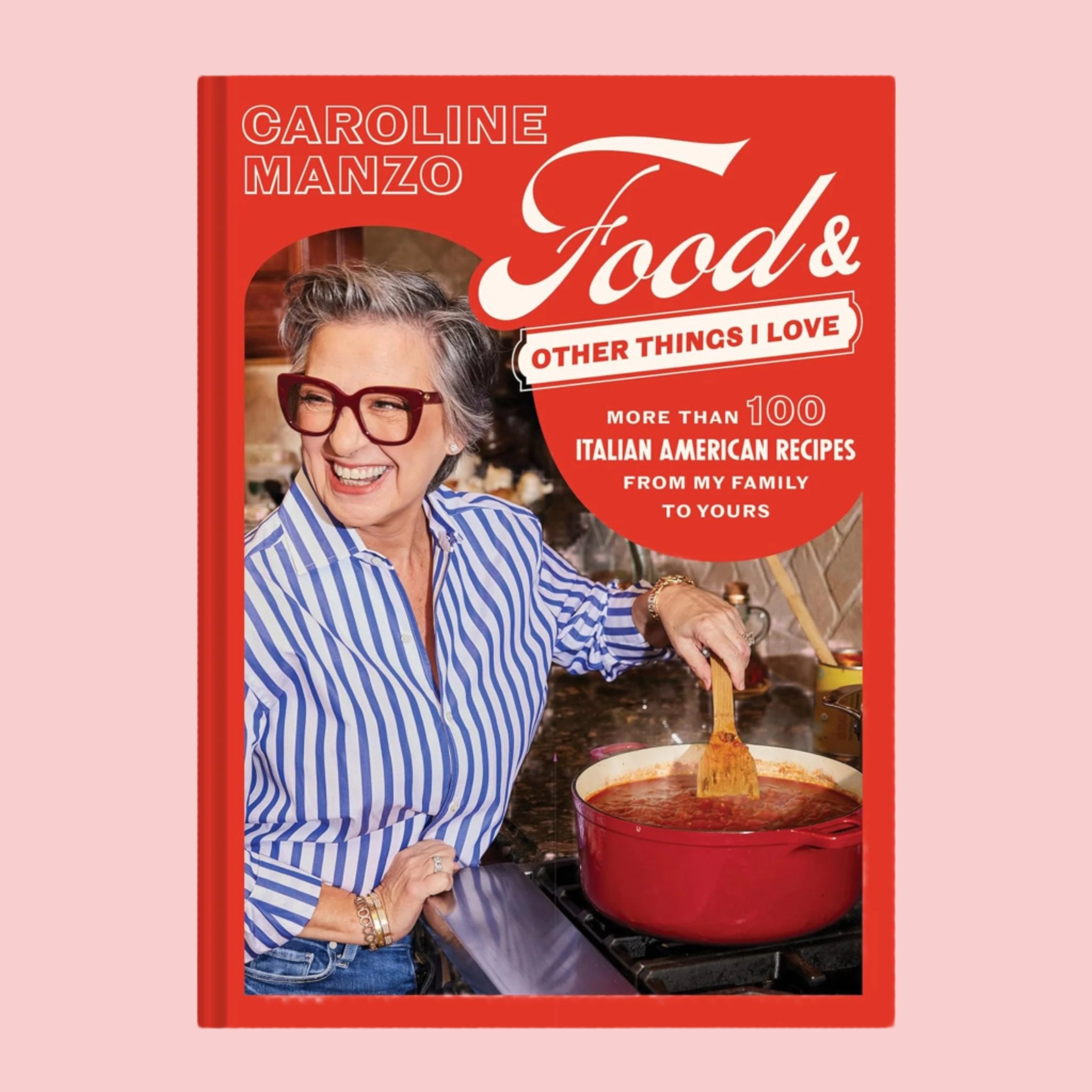 A red cook book with a photo of a chef stirring a red sauce and text that reads, &#39;Food &amp; Other Things I Love More Than 100 Italian American Recipes From My Family To Yours&#39;. 