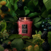 A red decorative glass jar candle with a matching lid. 