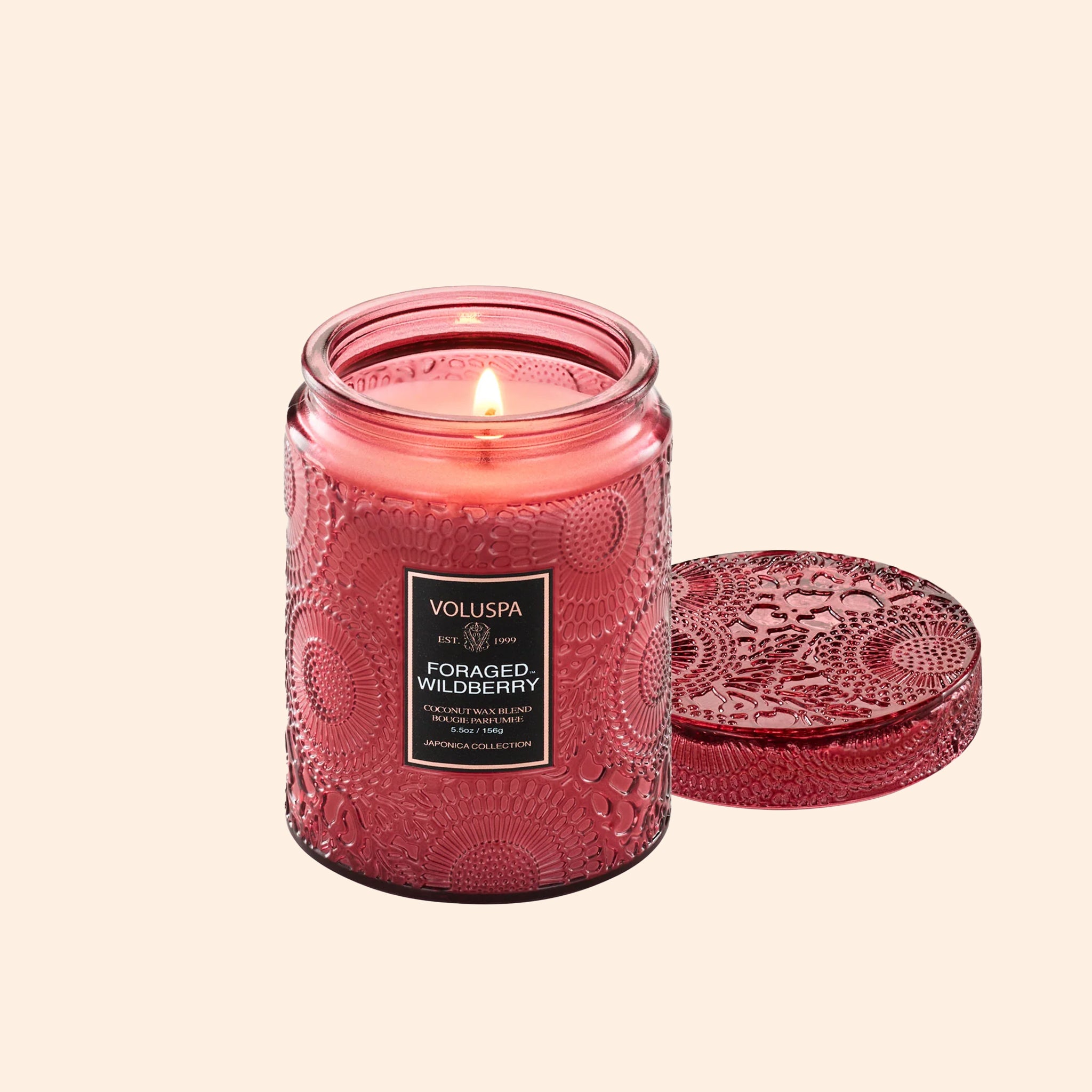 A red decorative glass jar candle with a matching lid. 