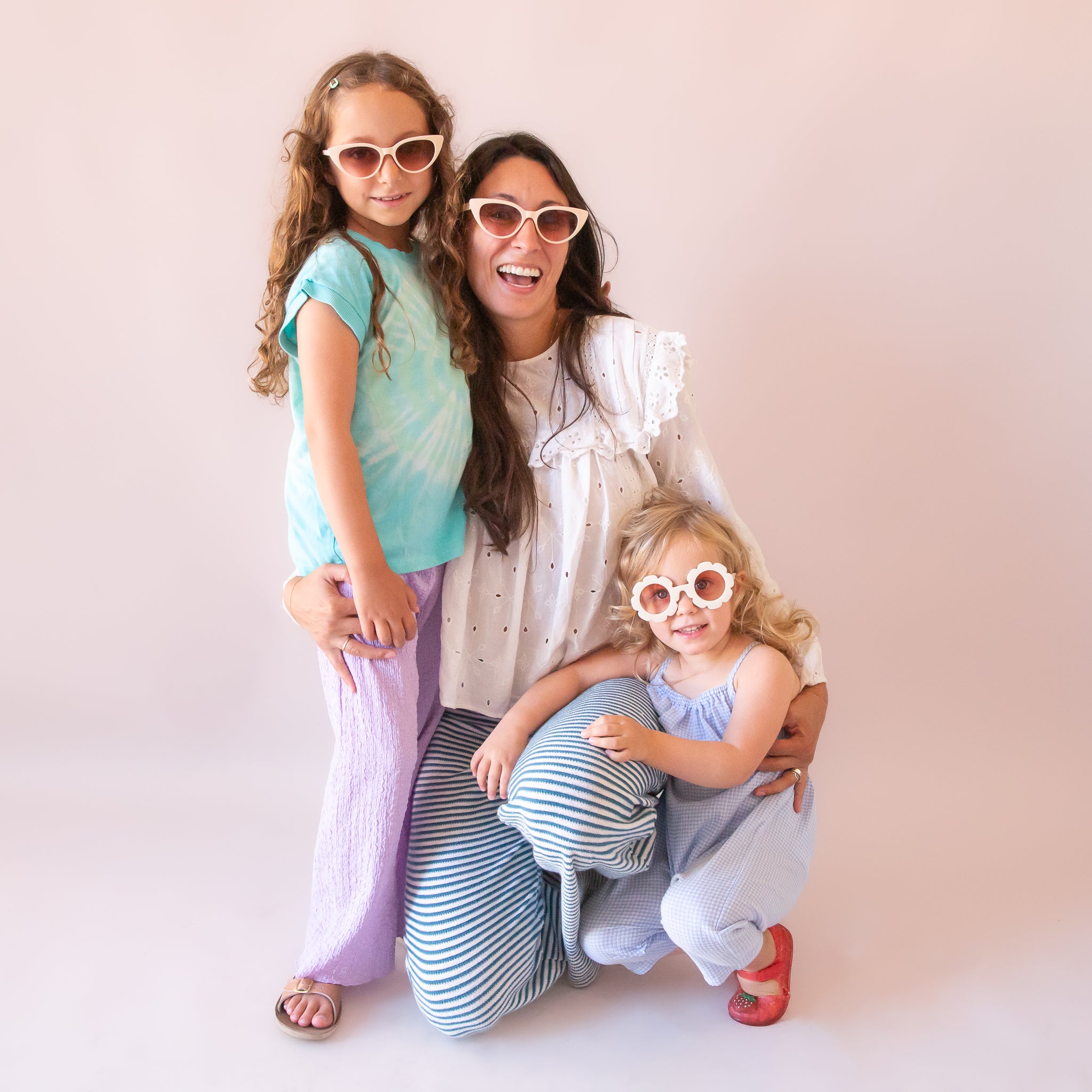 A mom and two daughters wearing the Frenchie sunglasses in the shade ivory in the adult and children&#39;s size. 