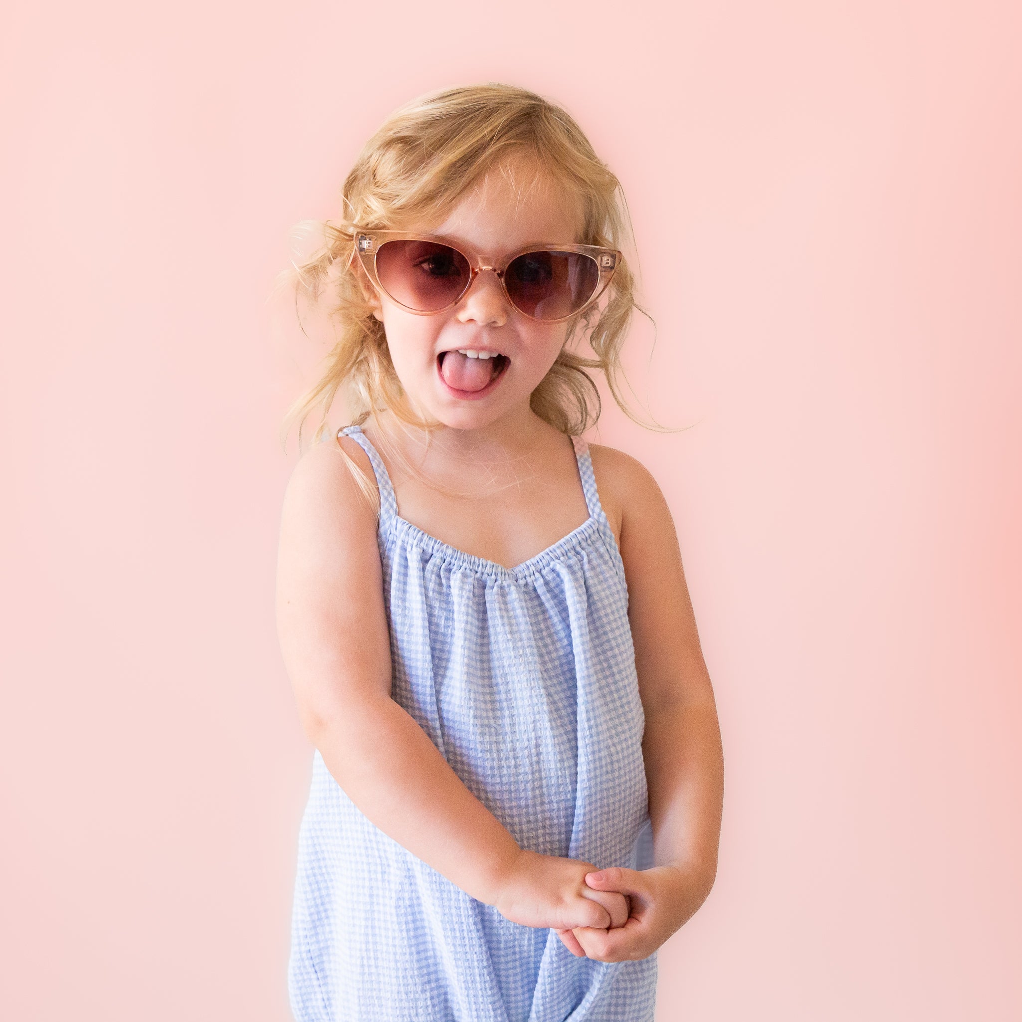 A pair of cat-eye shaped sunglasses with a translucent champagne color.