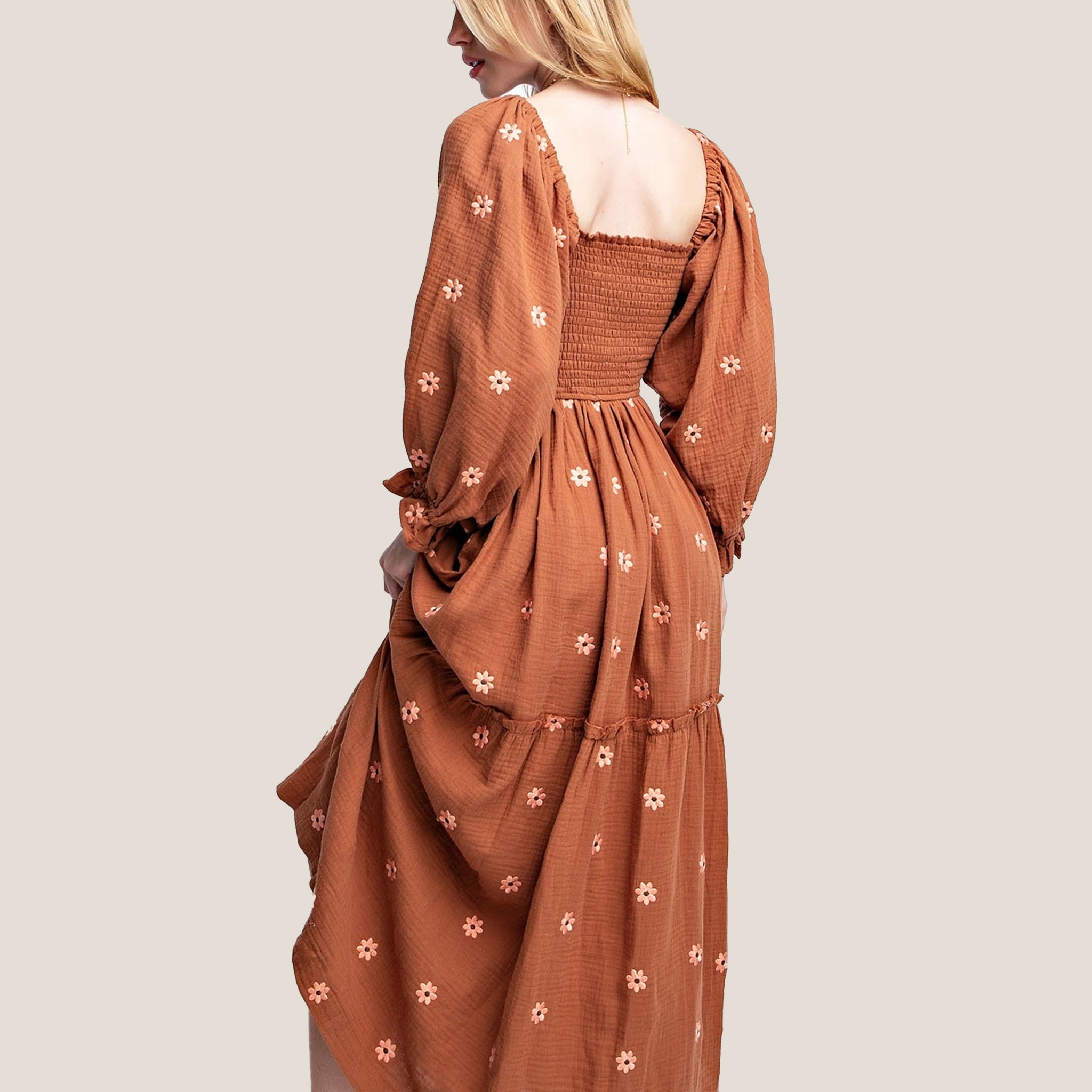 A rust / brown long-sleeve dress with flower embroidery.