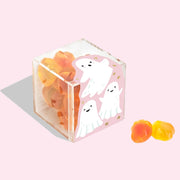 A clear acrylic container filled with orange ghost shaped gummy candies. 