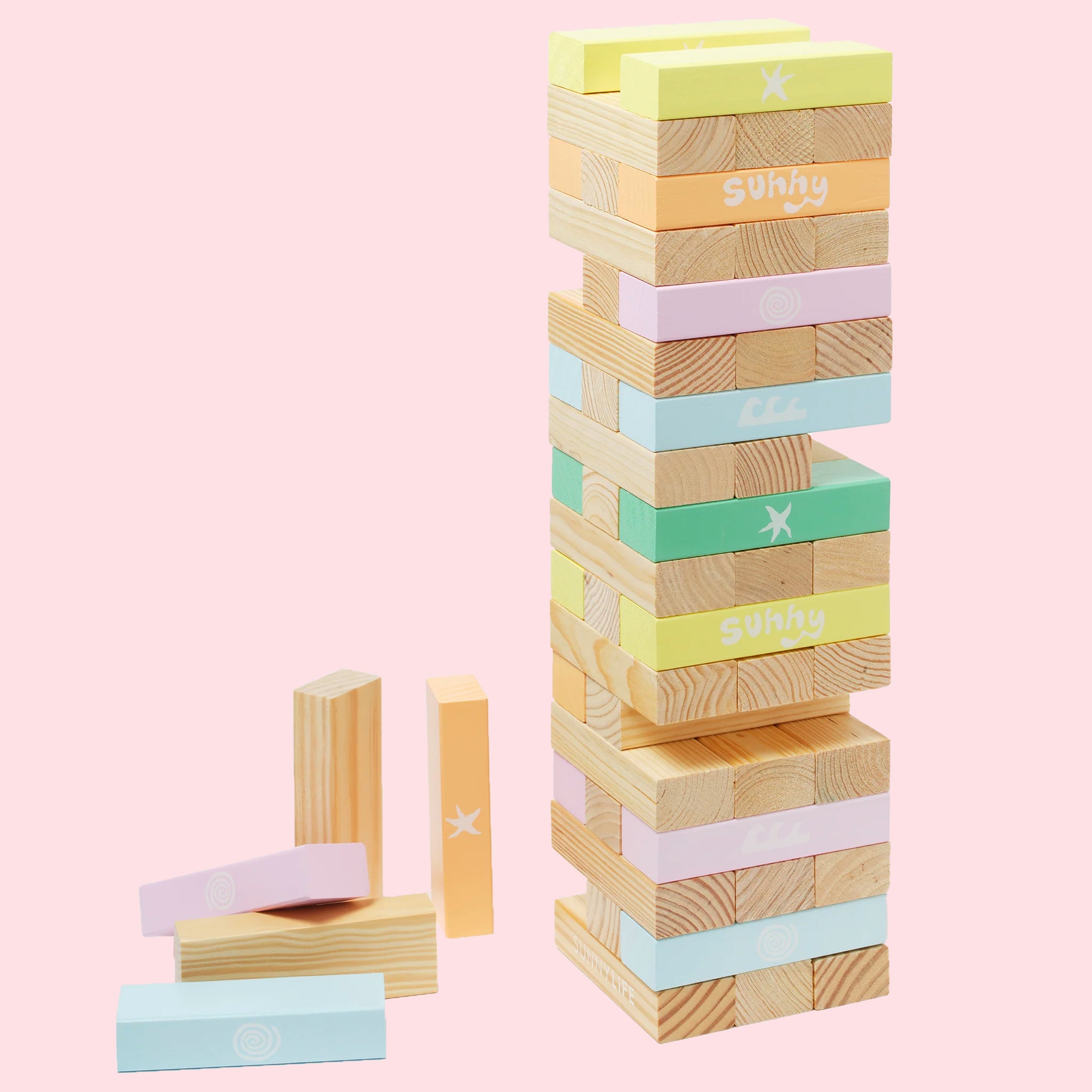 On a light pink background is a multi colored and wood stack of tumbler tower block game. 