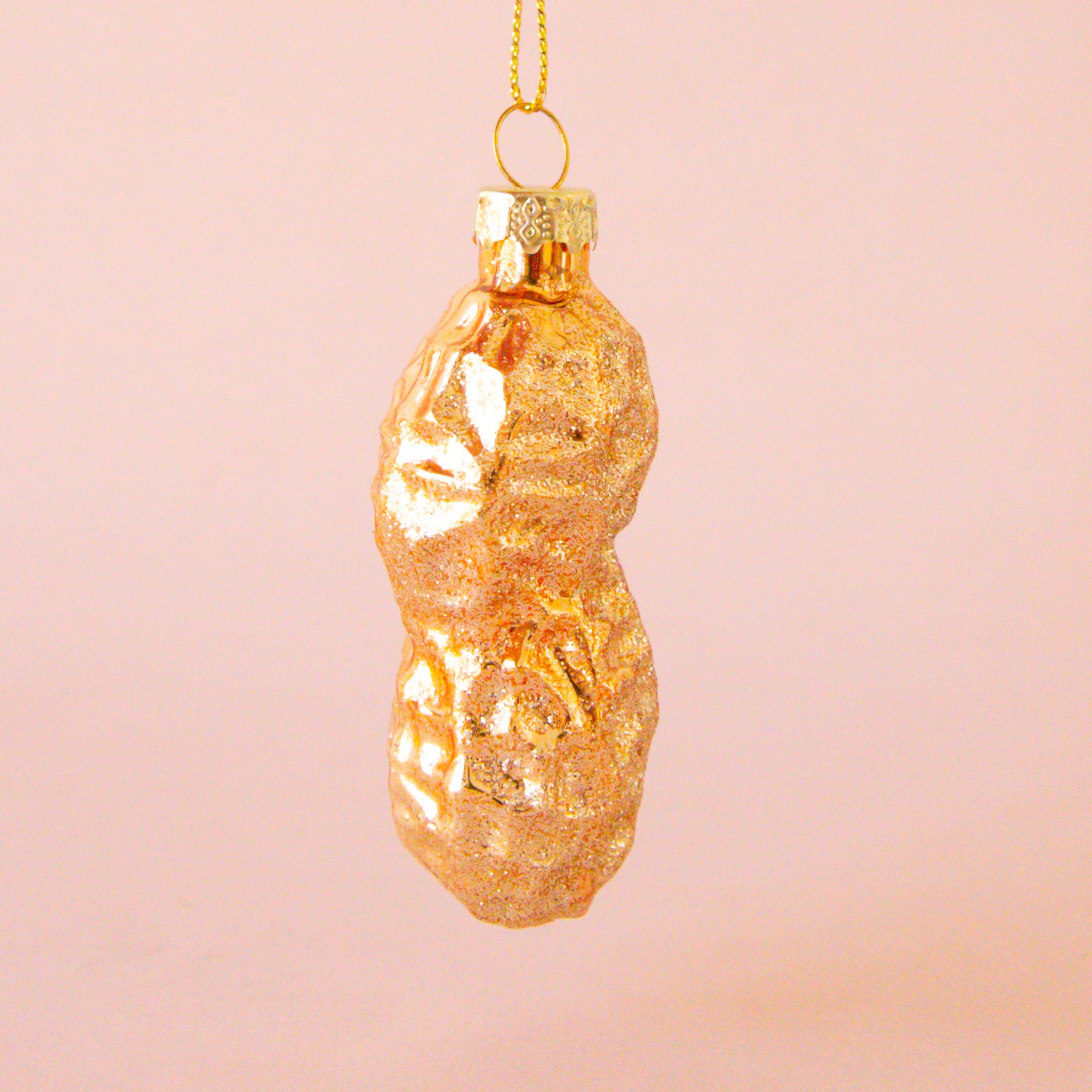 A glass peanut shaped ornament with glitter. 