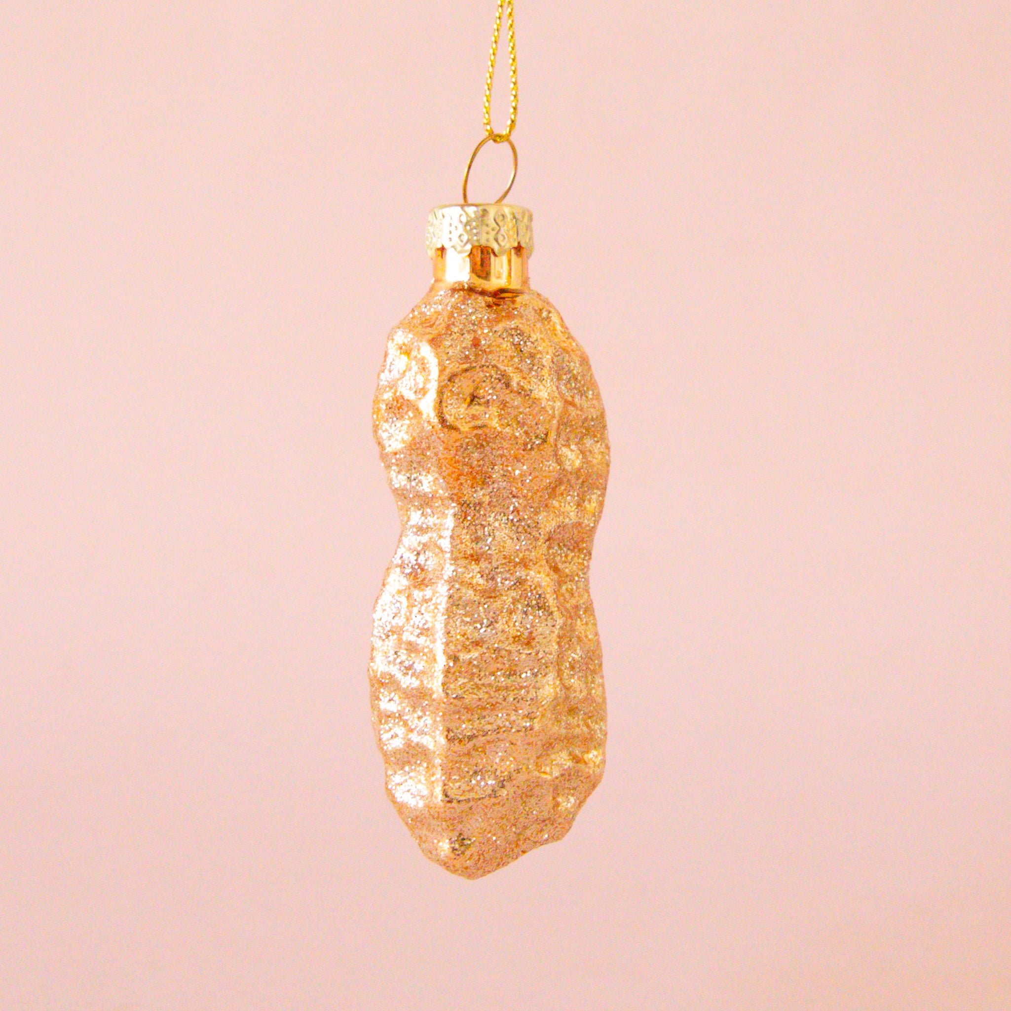 A glass peanut shaped ornament with glitter. 