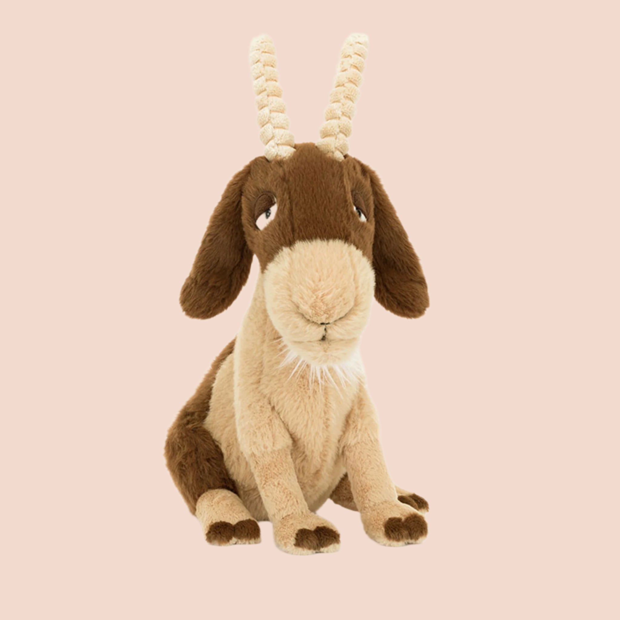 A brown and tan goat shaped stuffed animal with sleepy eyes, floppy ears and two soft horns. 